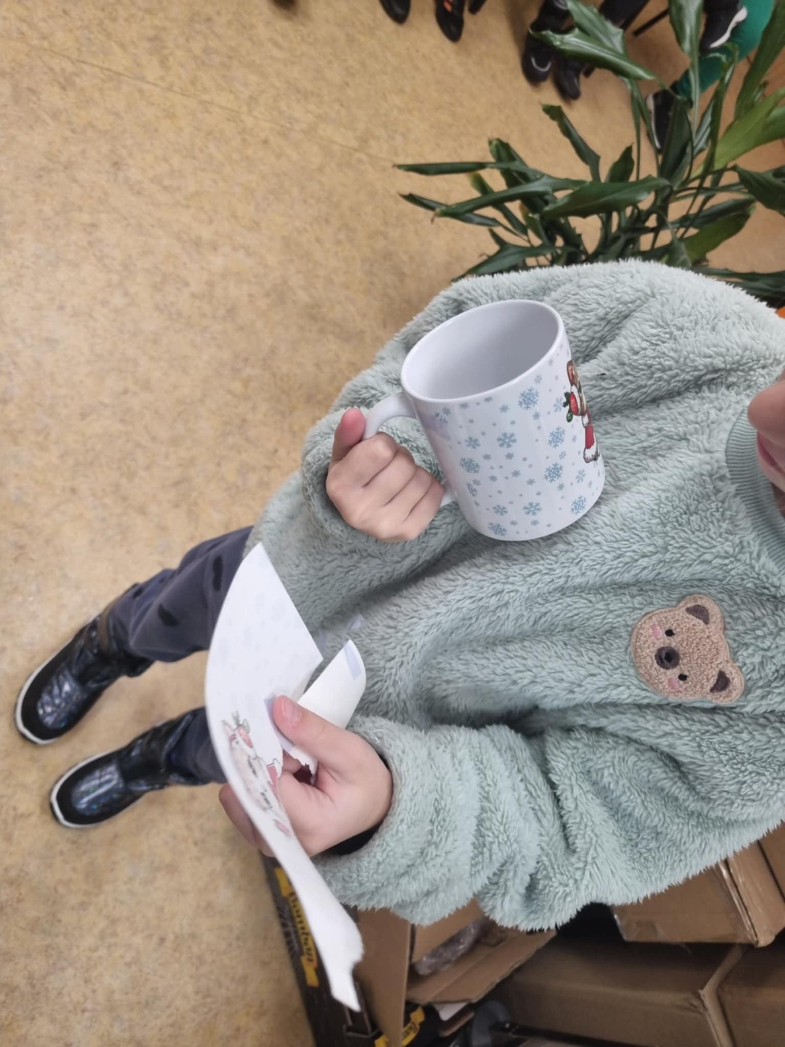 na zdjęciu dziewczynka z gotowym kubkiem z nadrukiem