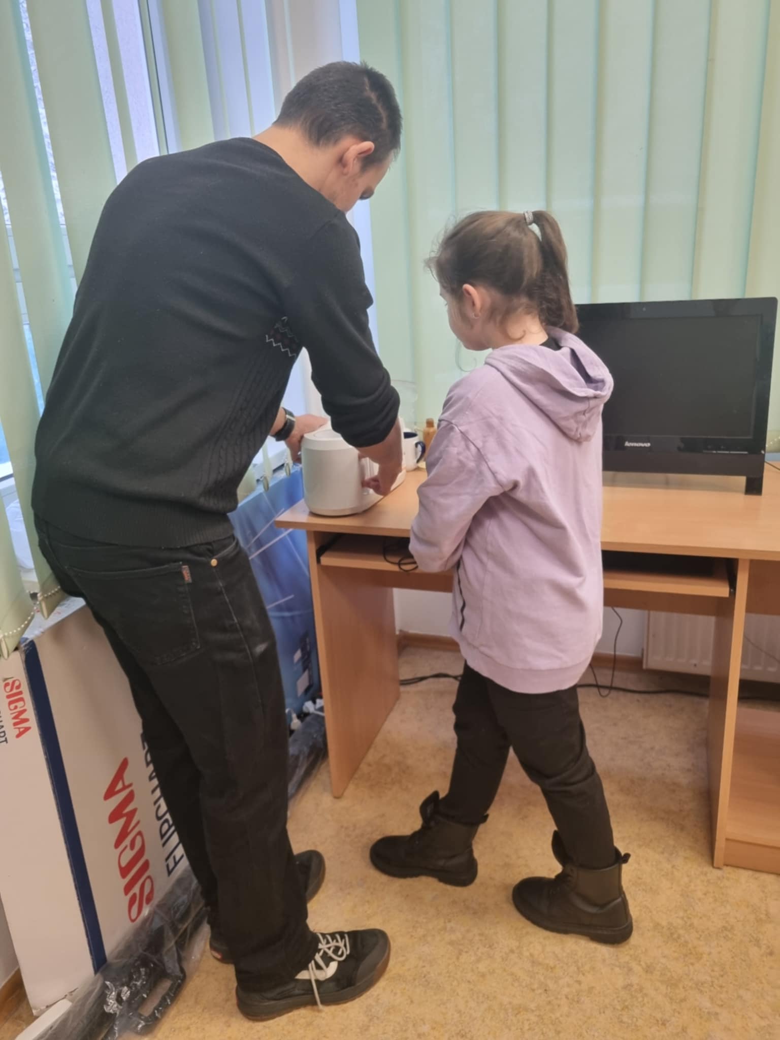 na zdjęciu dziewczynka i prowadzący przy maszynie do nadruków