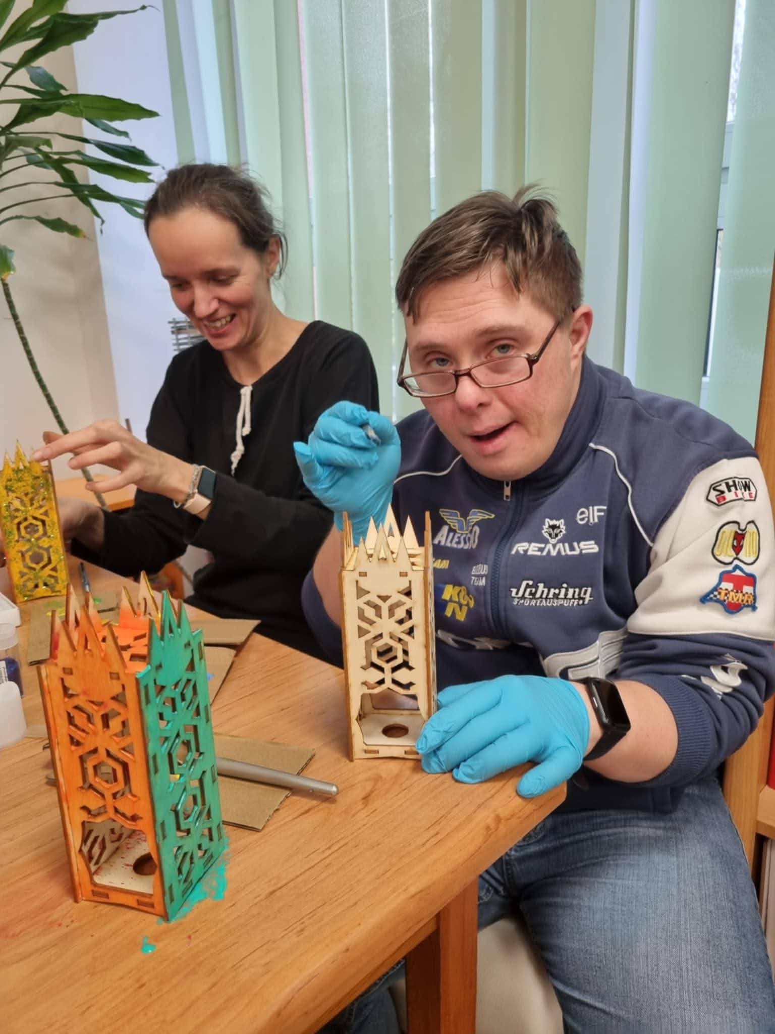 Osoba uczestnicząca w warsztatach prezentuje wykonany lampion.