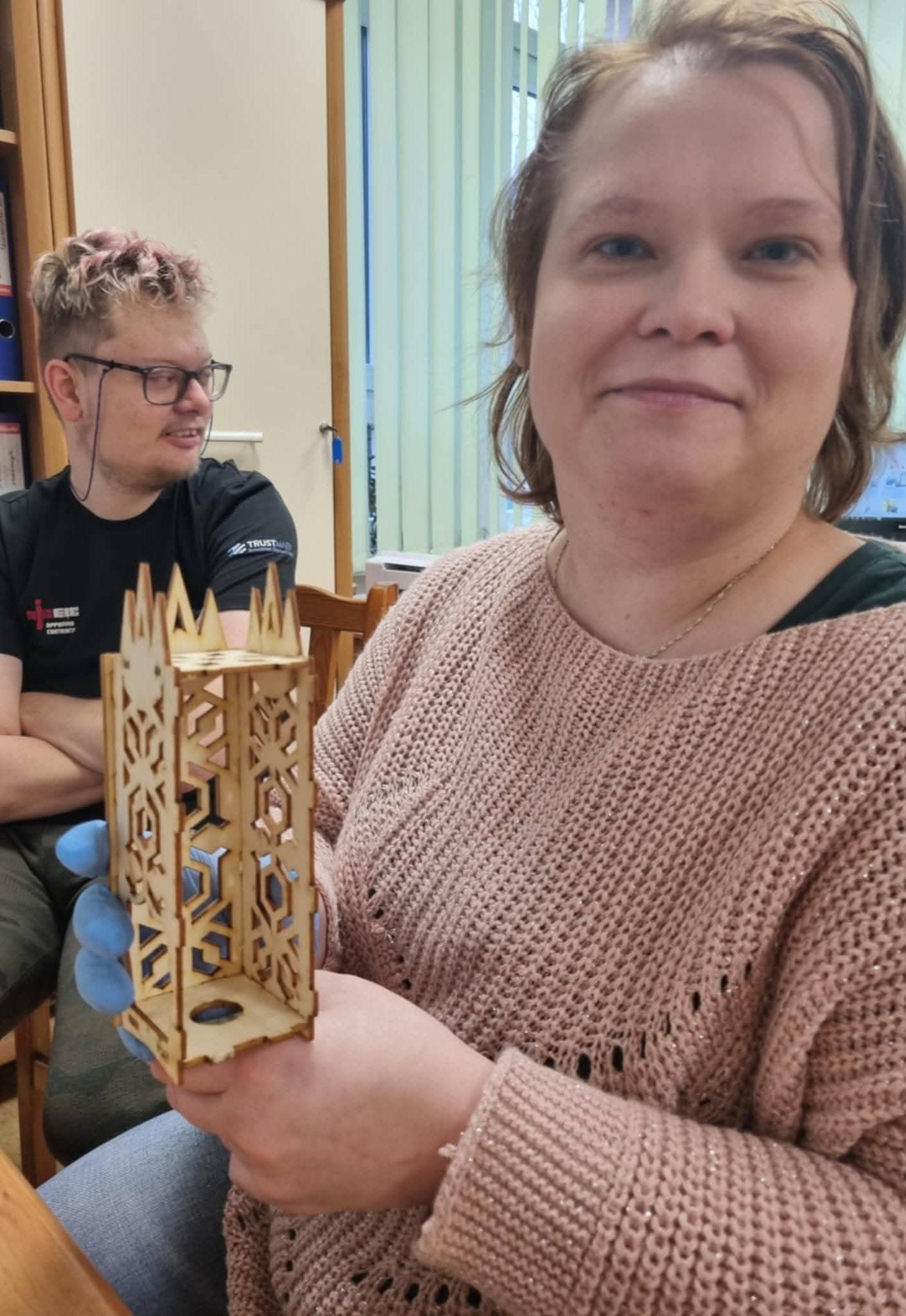 Osoba uczestnicząca w warsztatach prezentuje wykonany lampion.