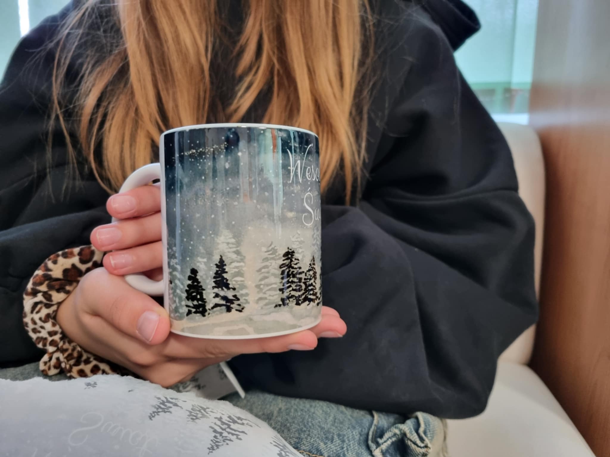 na zdjęciu osoba trzymająca Mikołajkowy kubek