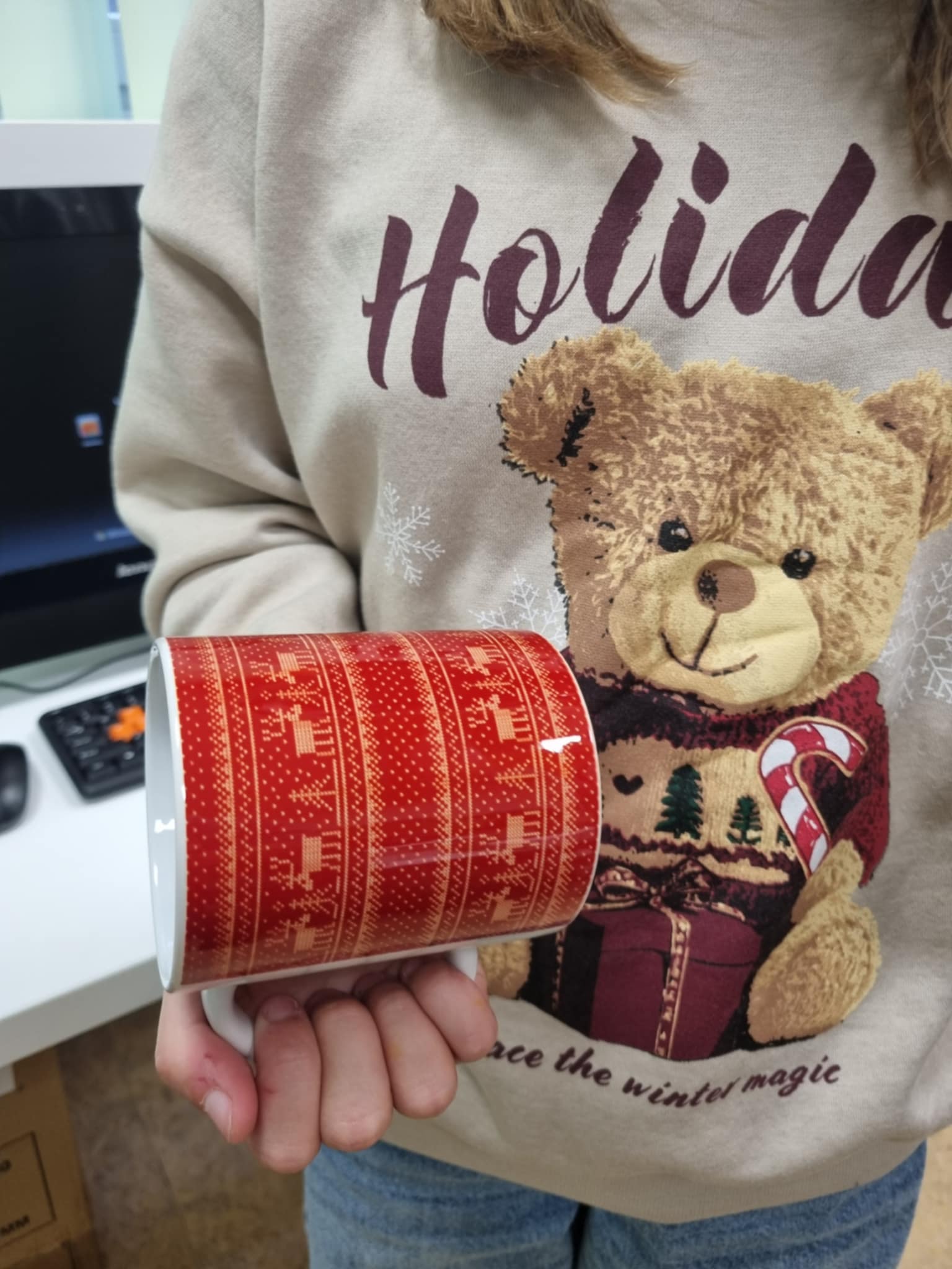 dziewczynka trzymająca kubek z światecznym nadrukiem