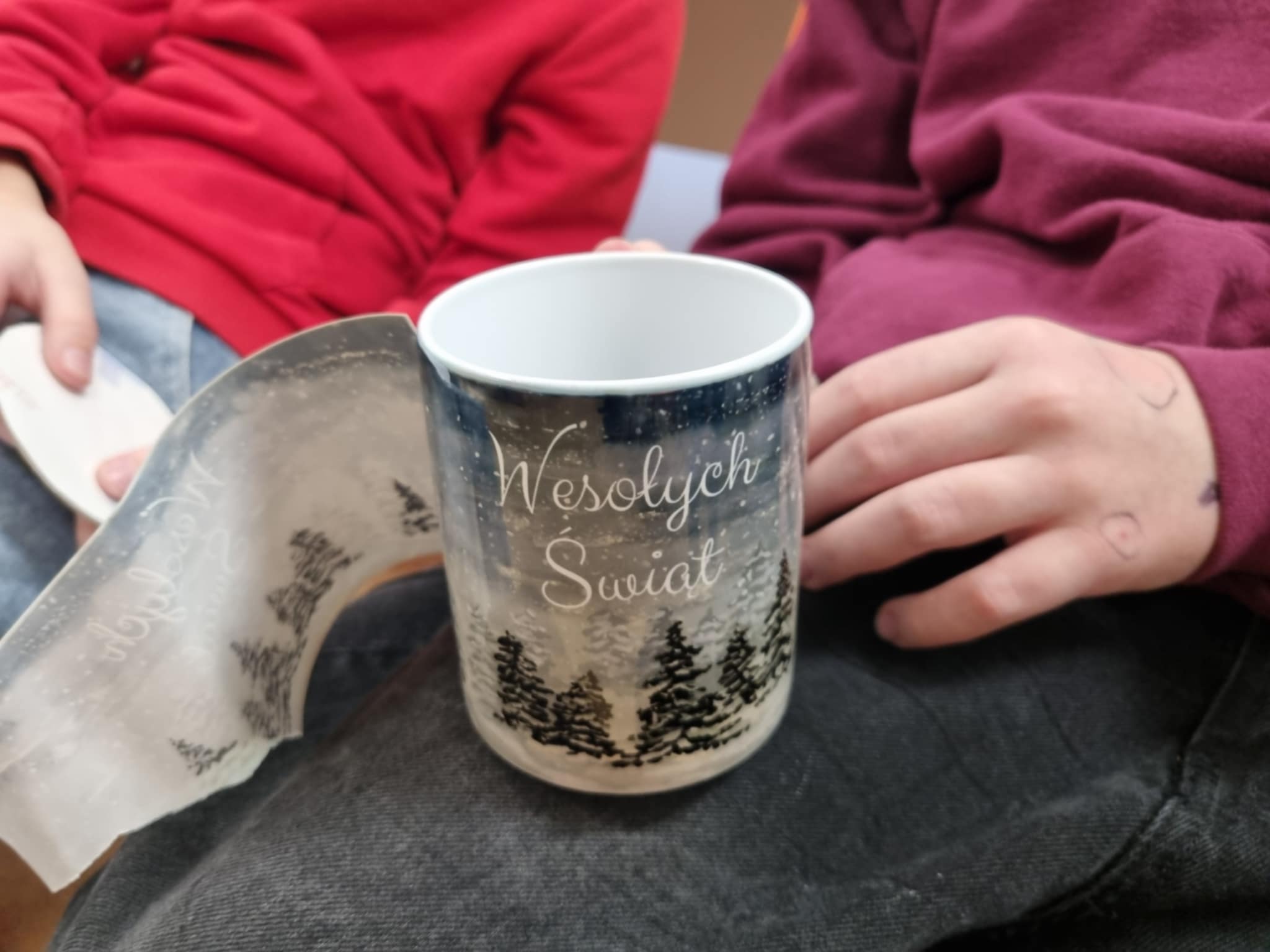 na zdjęciu osoba trzymająca Mikołajkowy kubek
