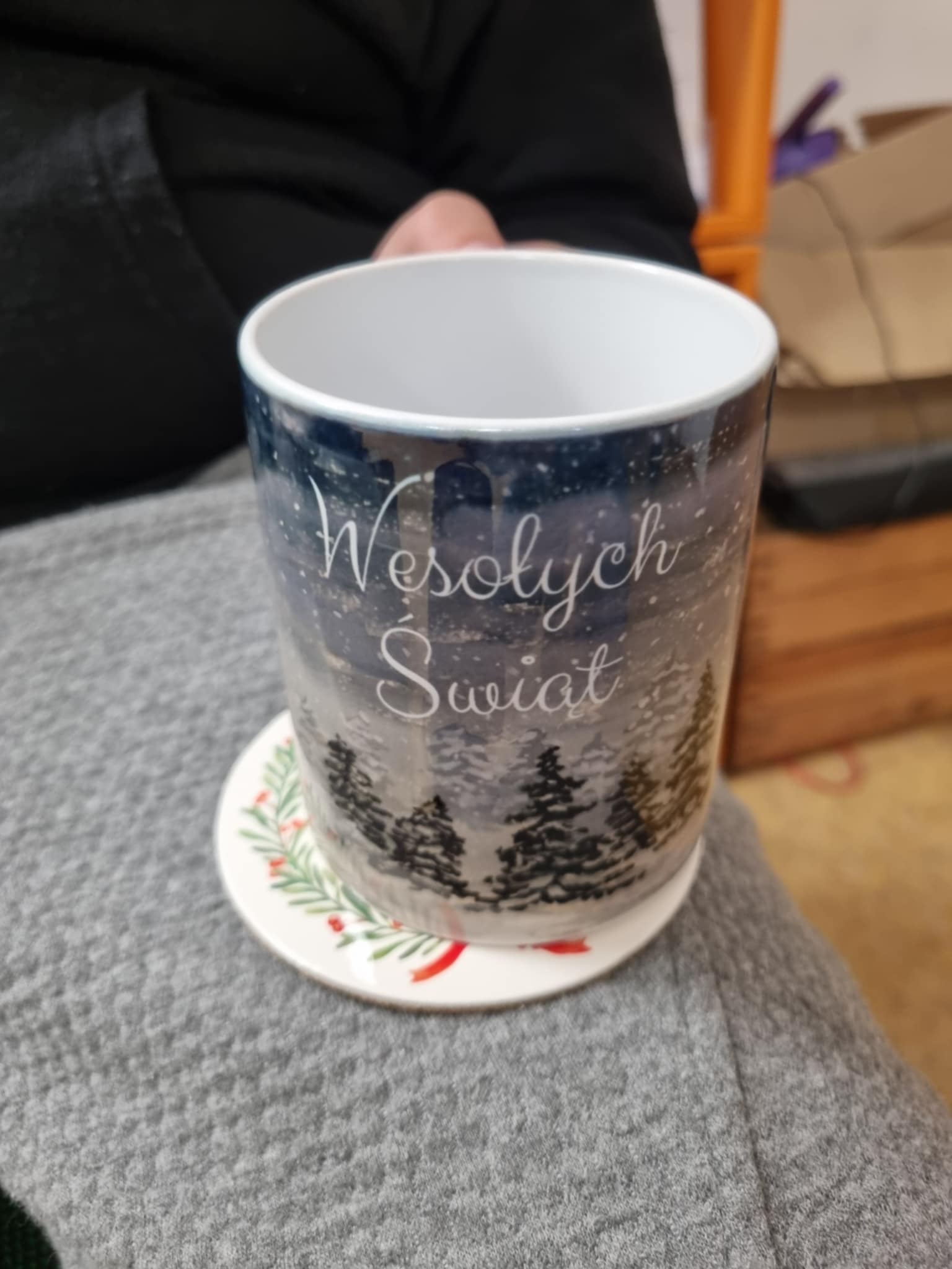 na zdjęciu osoba trzymająca Mikołajkowy kubek