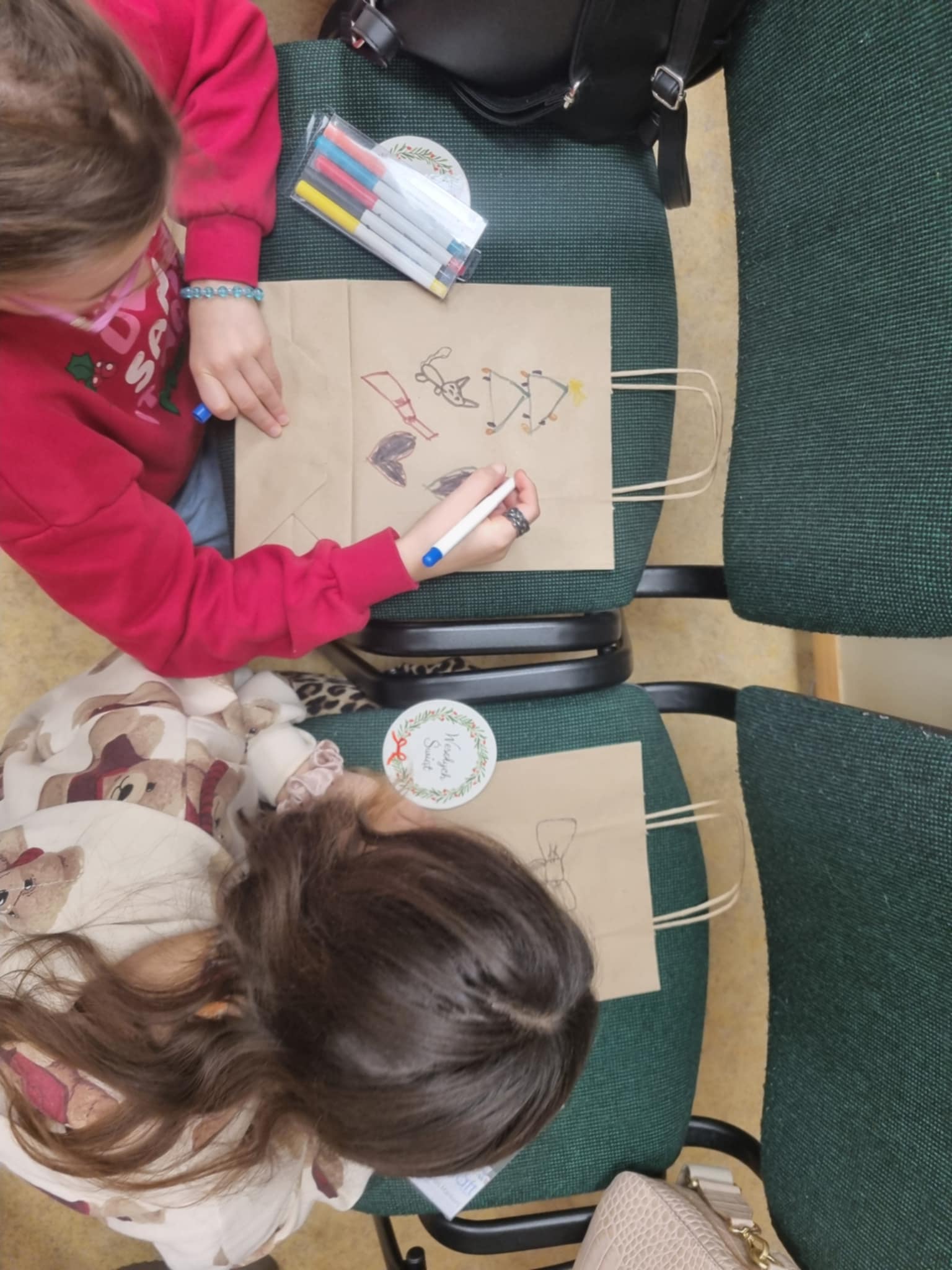 dwie dziewczynki malujące na torbach świątecznych
