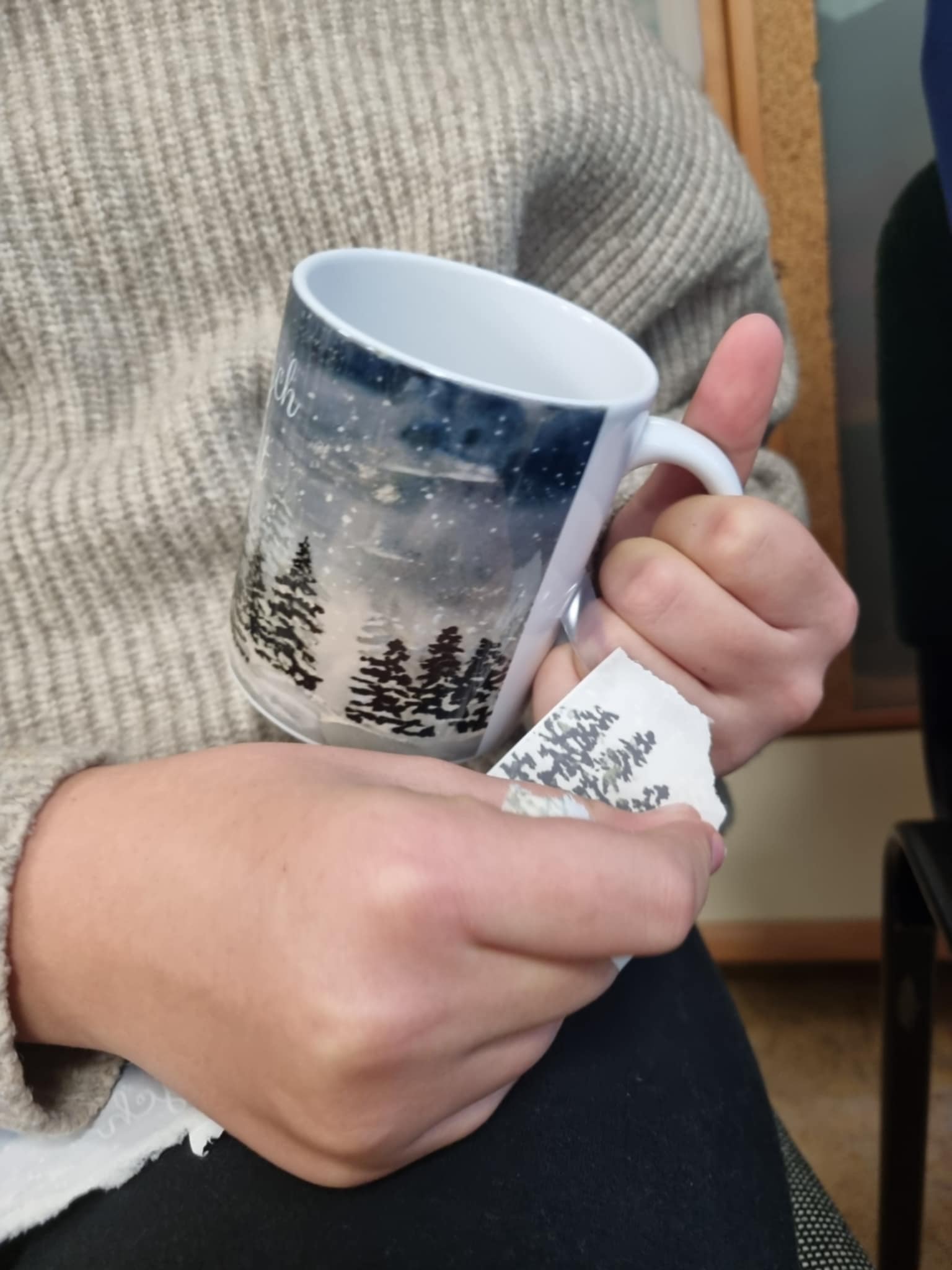 na zdjęciu osoba trzymająca Mikołajkowy kubek