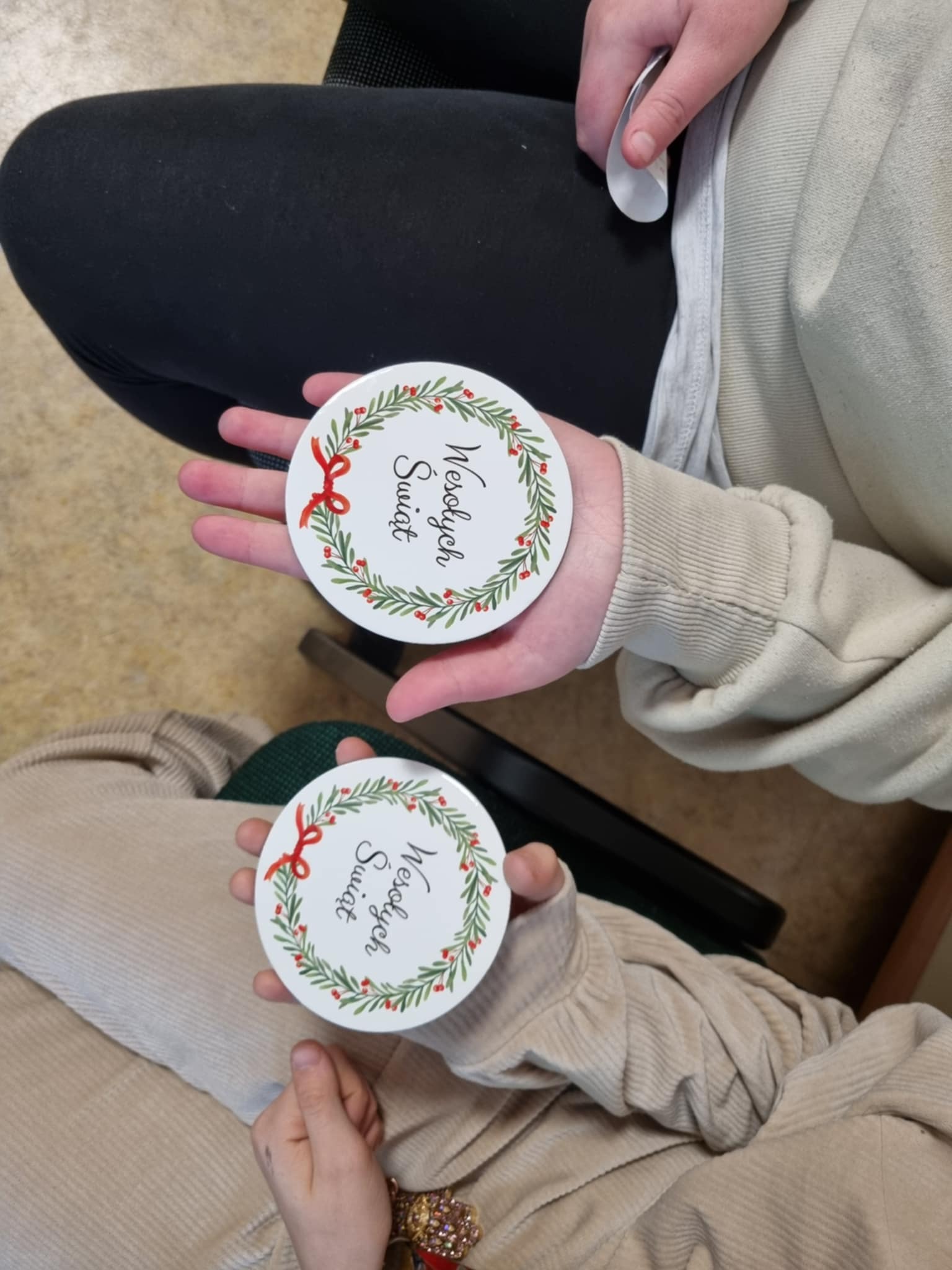 dwie osoby trzymające podkładki pod kubek z nadrukiem 