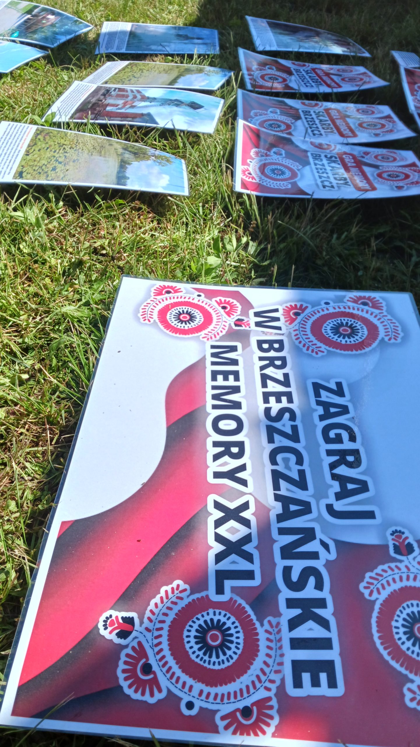 Zdjęcie gry plenerowej memory XXL, na głównej karcie widać napis: Zagraj w brzeszczańskie memory XXL