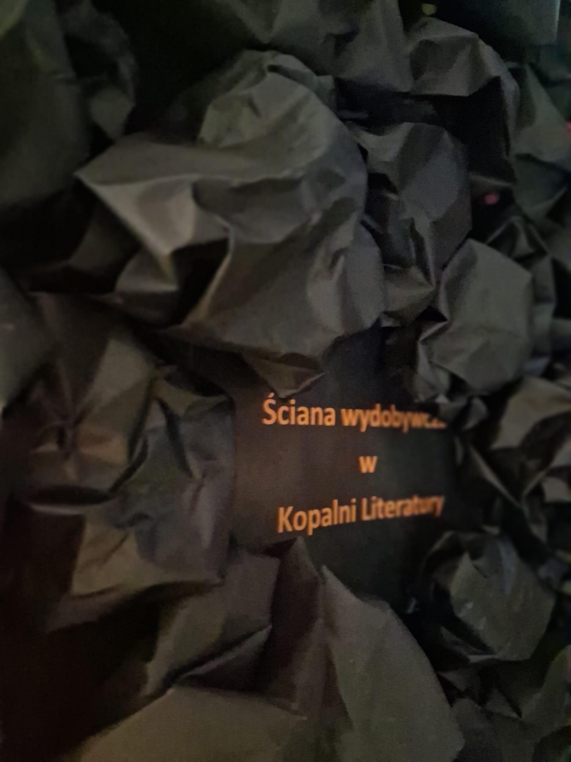 czarne, zmięte kartki papieru imitujące węgiel na tzw. 