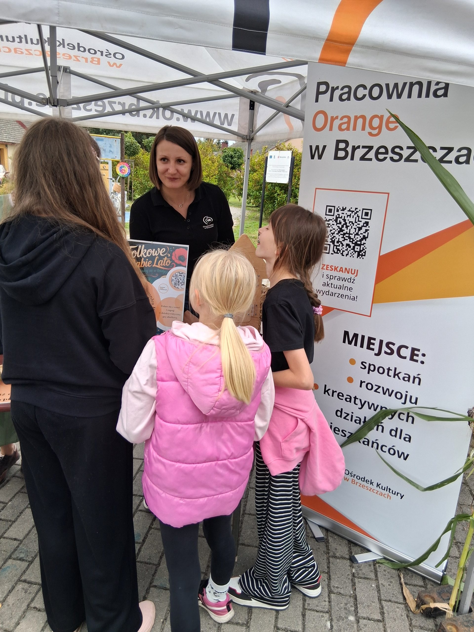 grupa dzieci stojących przy stoisku Pracowni Orange