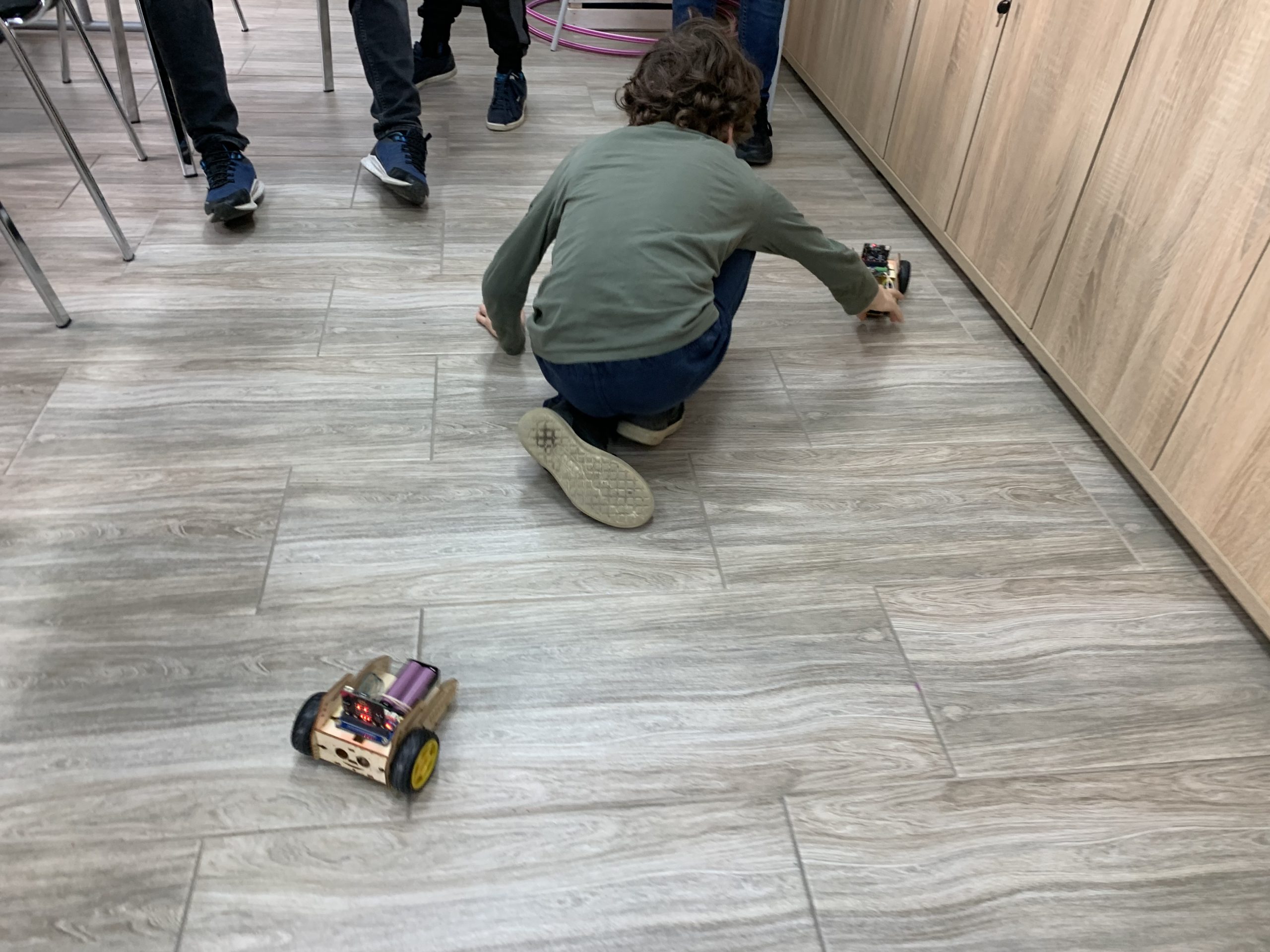 Uczestnik warsztatów oraz zaprogramowany robot.
