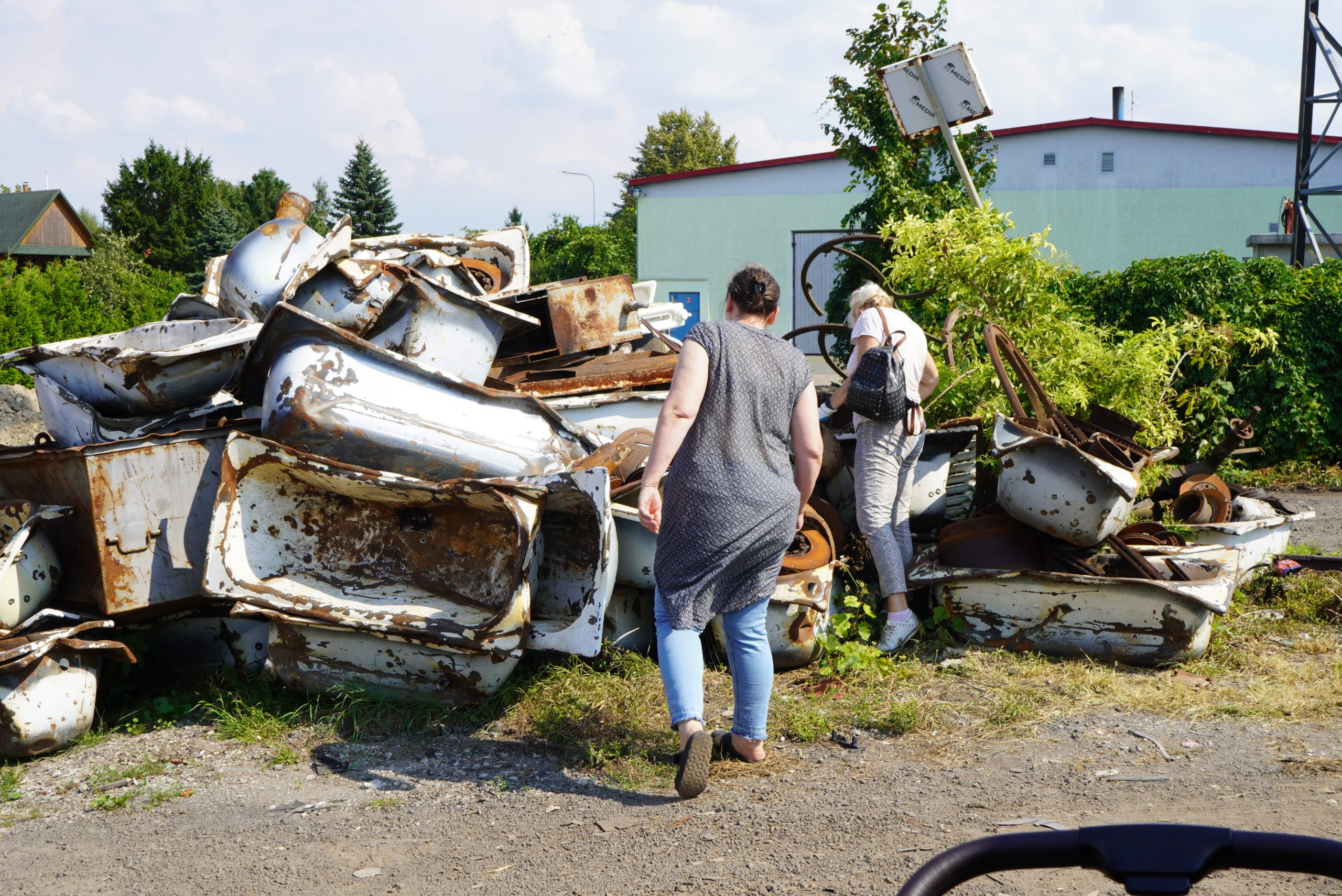 Uczestniczki warsztatu na wysypisku śmieci poszukują rzeczy do wykorzystania.