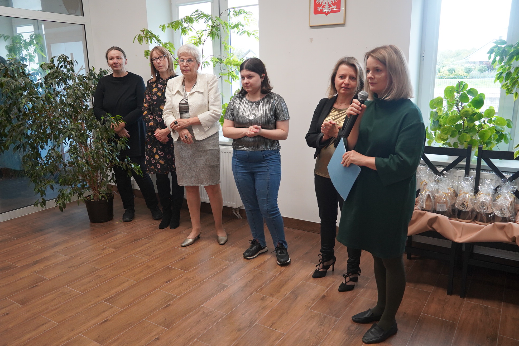 zdjęcie sześciu kobiet, jedna mówi przez mikrofon
