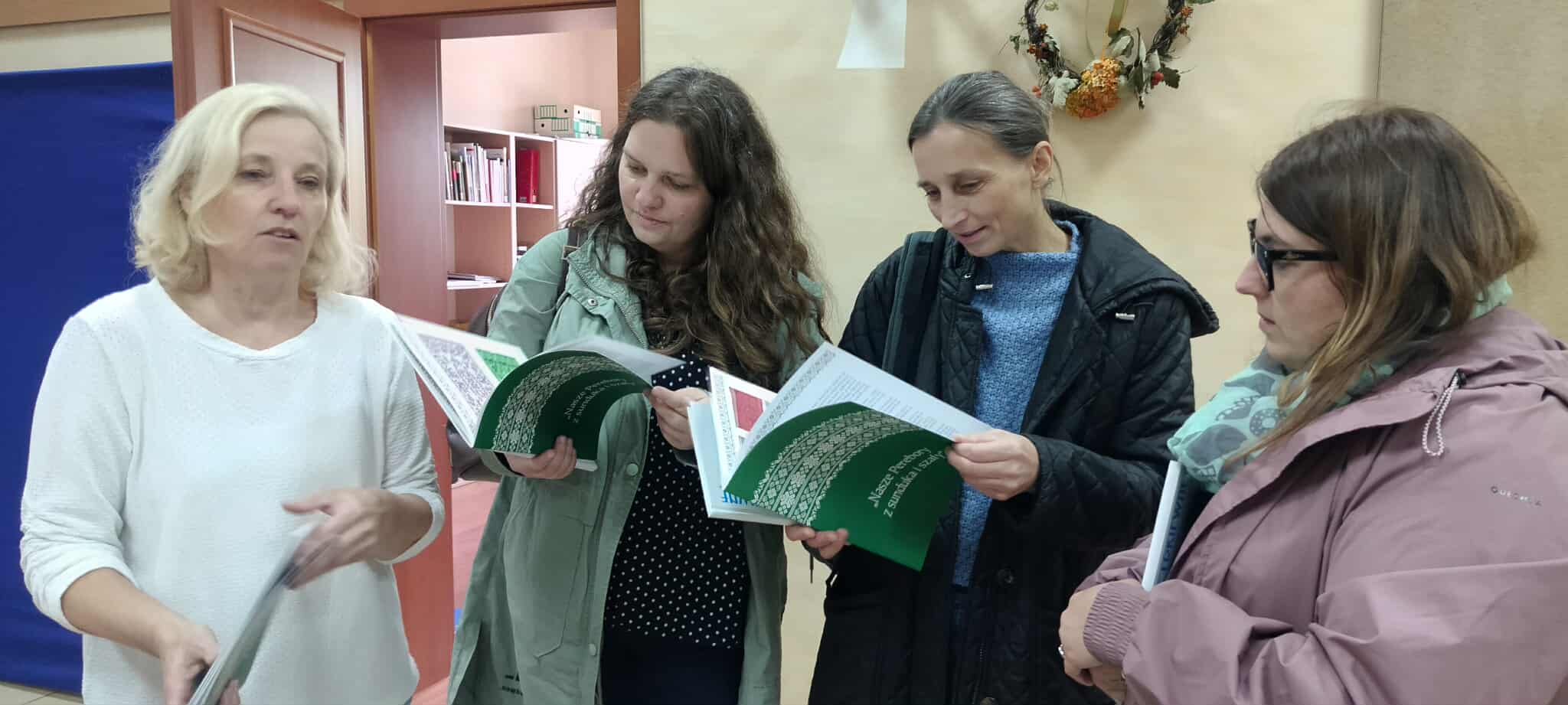 na zdjęciu dwie kobiety, w rękach mają książkę