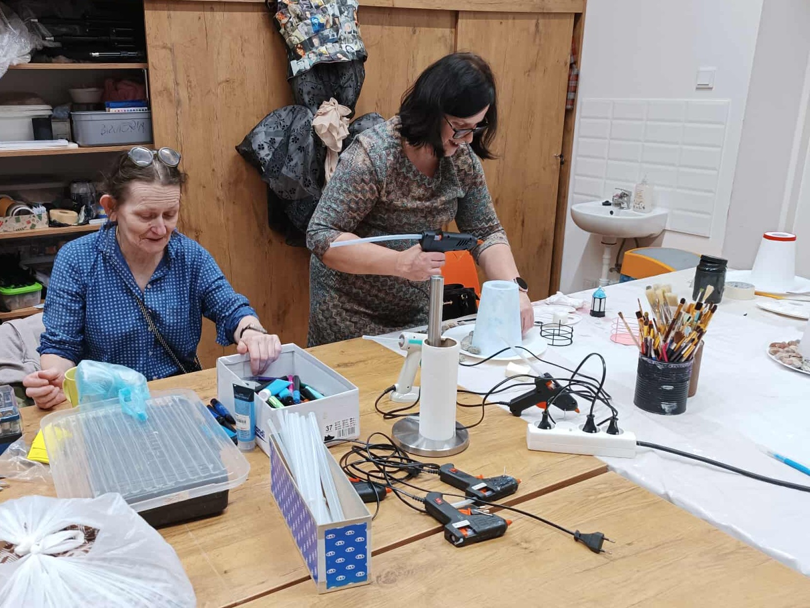 Zdjęcie dwóch kobiet tworzących latarnie morskie.