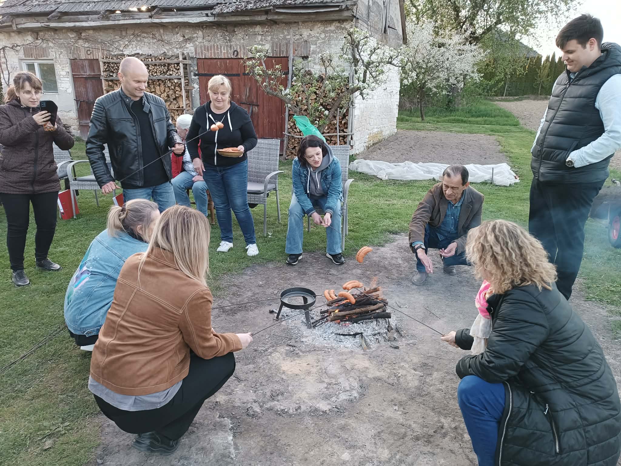 Grupa osób przy ognisku.