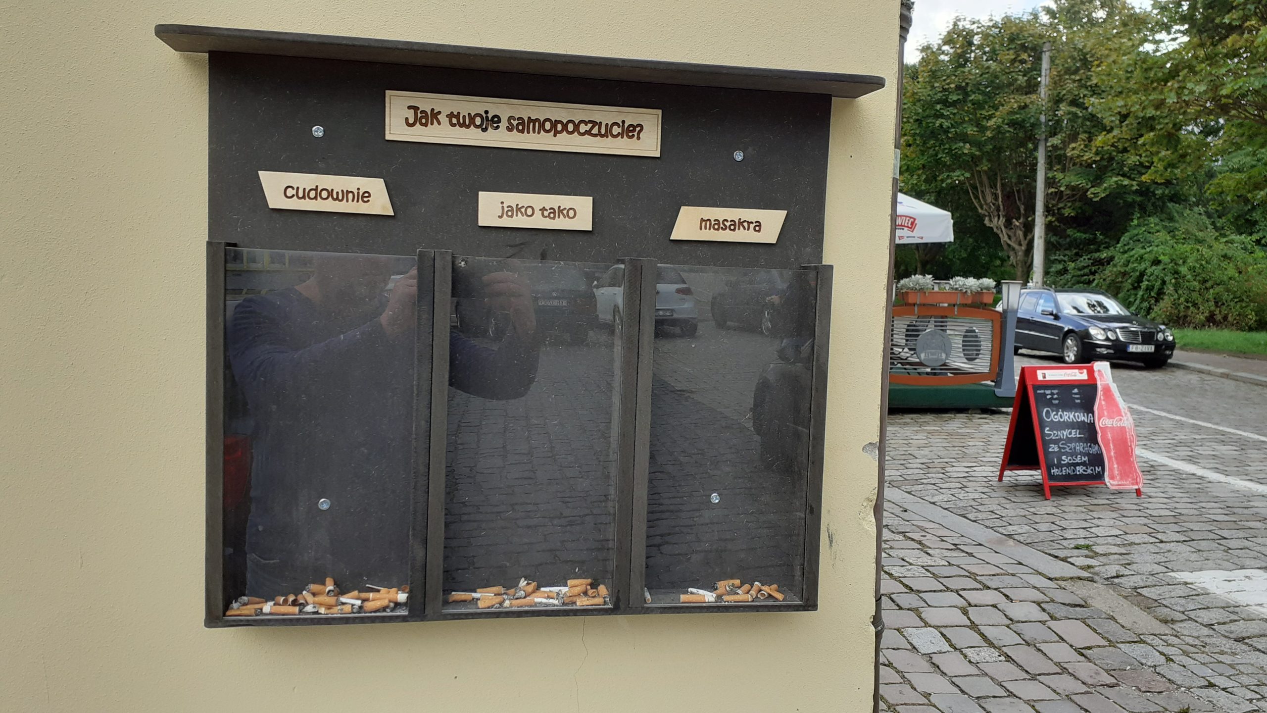 Na zdjęciu skrzyneczka na niedopałki papierosów. Na górze widnieje napis: 