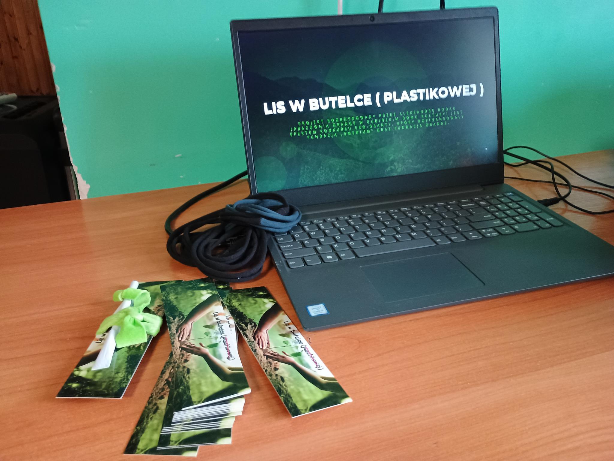 na stole stoi laptop z prezentacja z napisem 