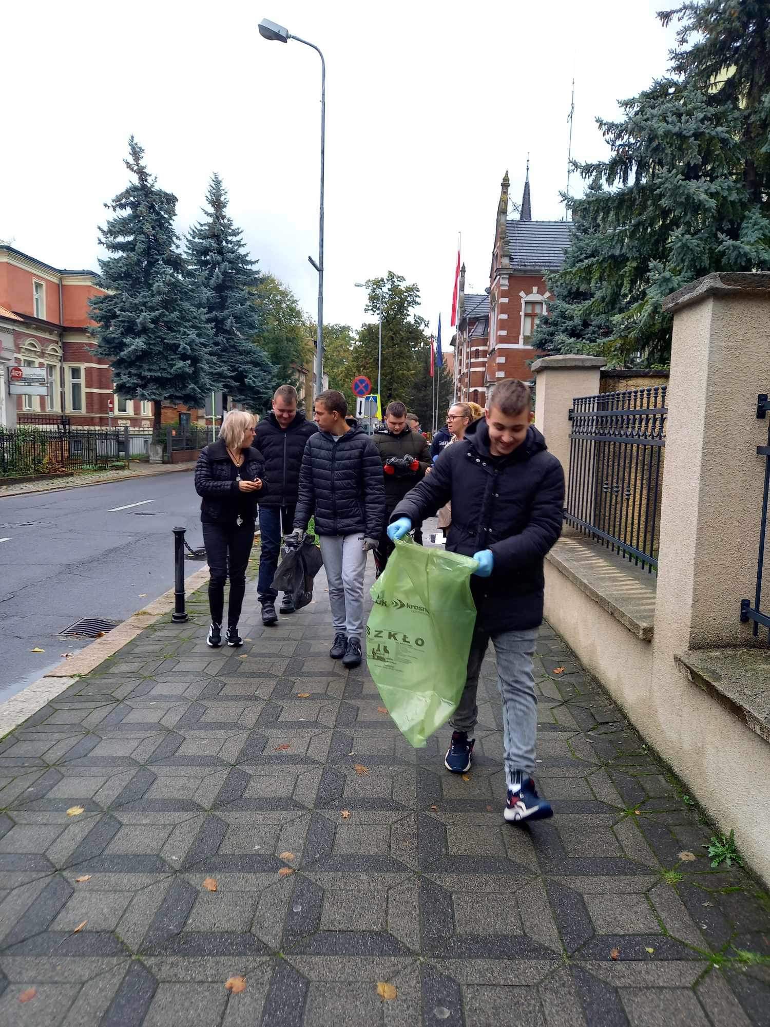 grupa ludzi w terenie sprząta ulice