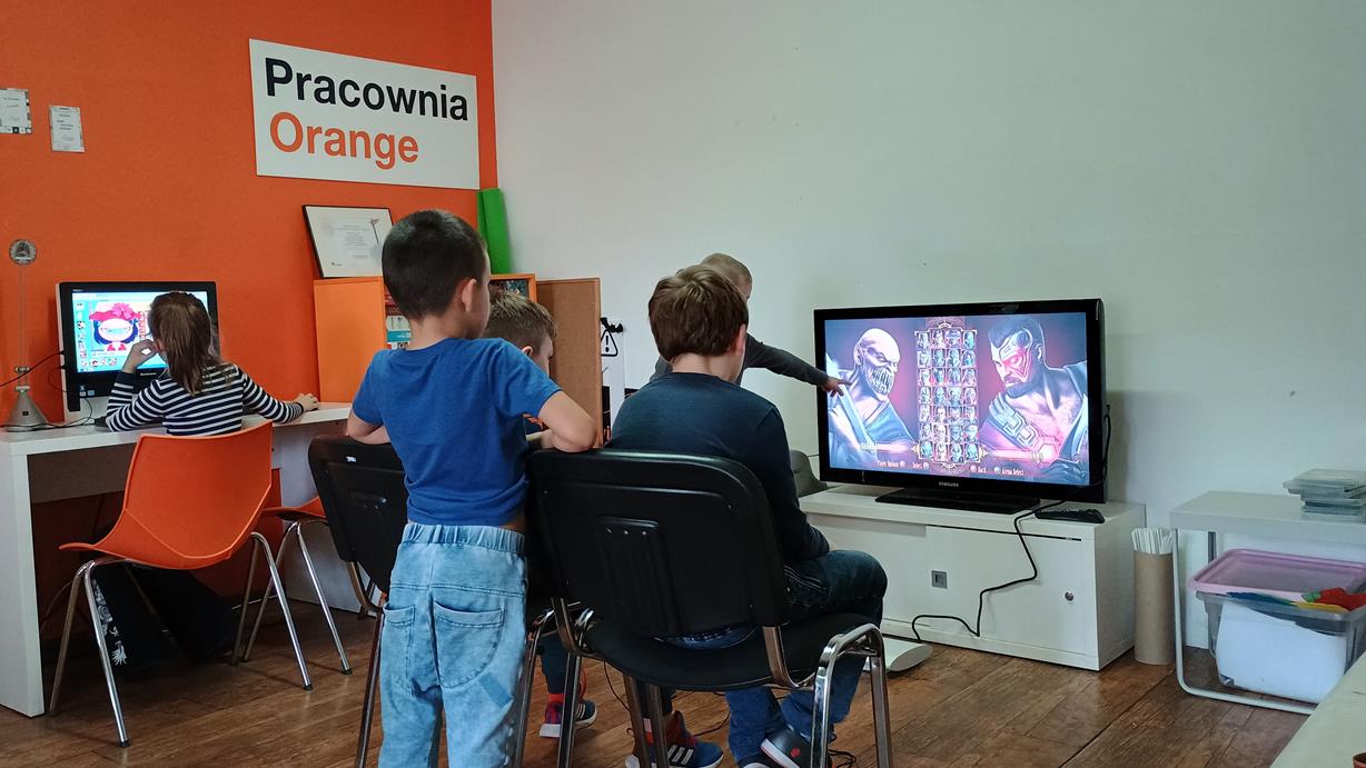 na zdjęciu dzieci grające na playstation w pracowni orange