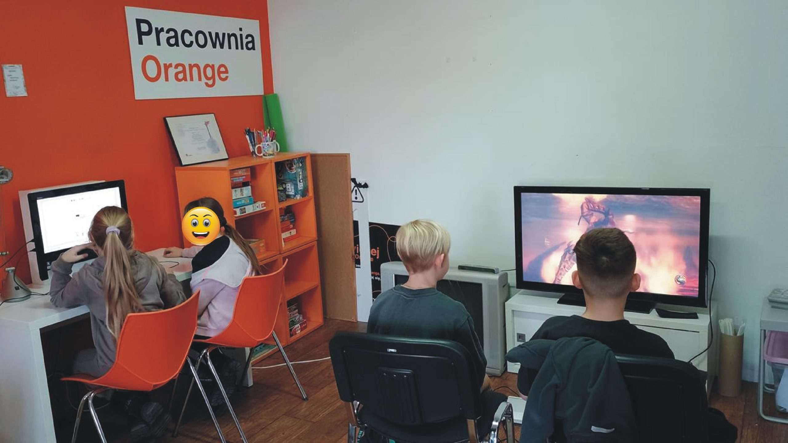 na zdjęciu z pracowni orange widać dzieci grające, oglądające coś na komputerze, dwójka chłopców ze zdjęcia gra w grę na playstation