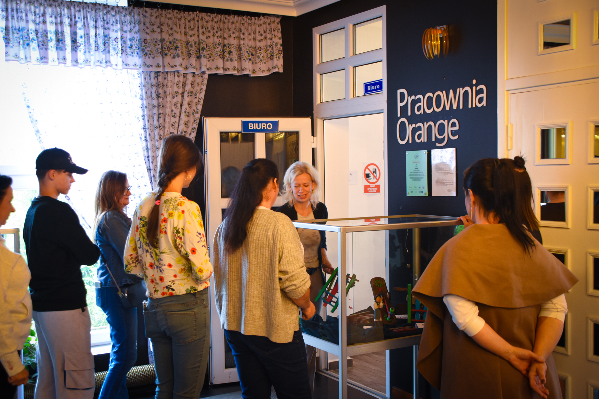 Zdjęcie grupy osób w kolejce do gabloty w Pracowni Orange