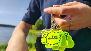 Zbliżenie na fosforyzujące zawieszki z napisem "Chmielno"