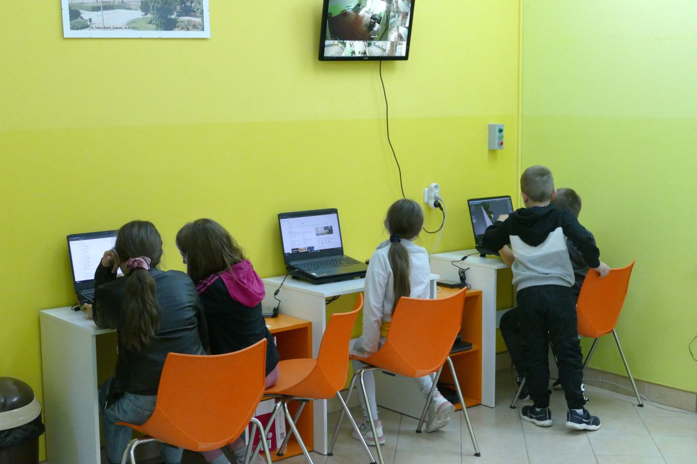 Zdjęcie. Dzieci siedzące przy stanowiskach komputerowych.