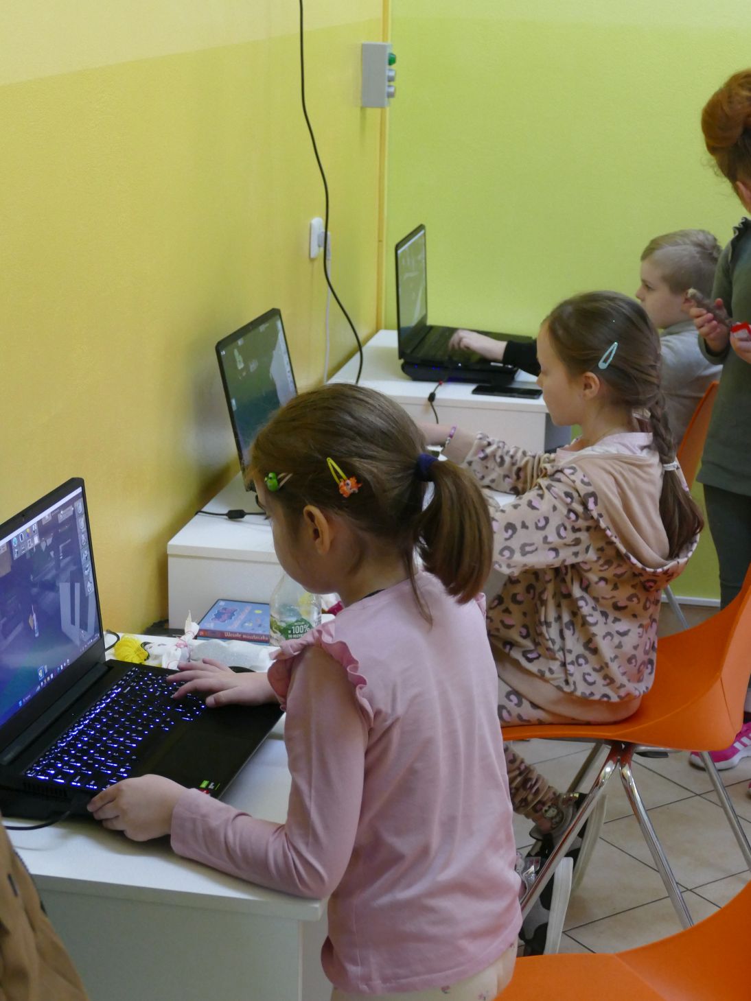 Dzieci siedzące przed komputerami.