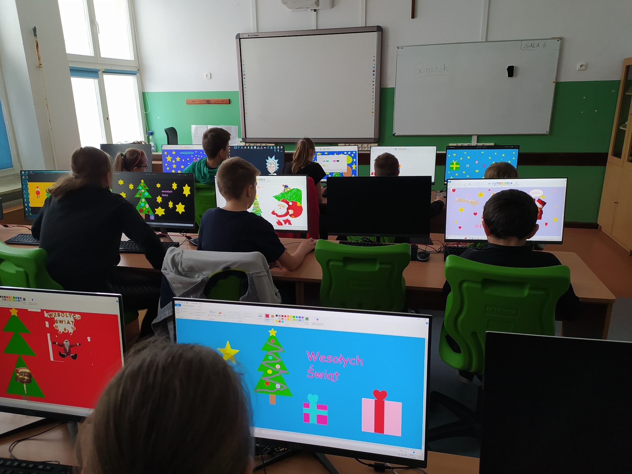 dzieci w klasie projektują na komputerach kartki świąteczne