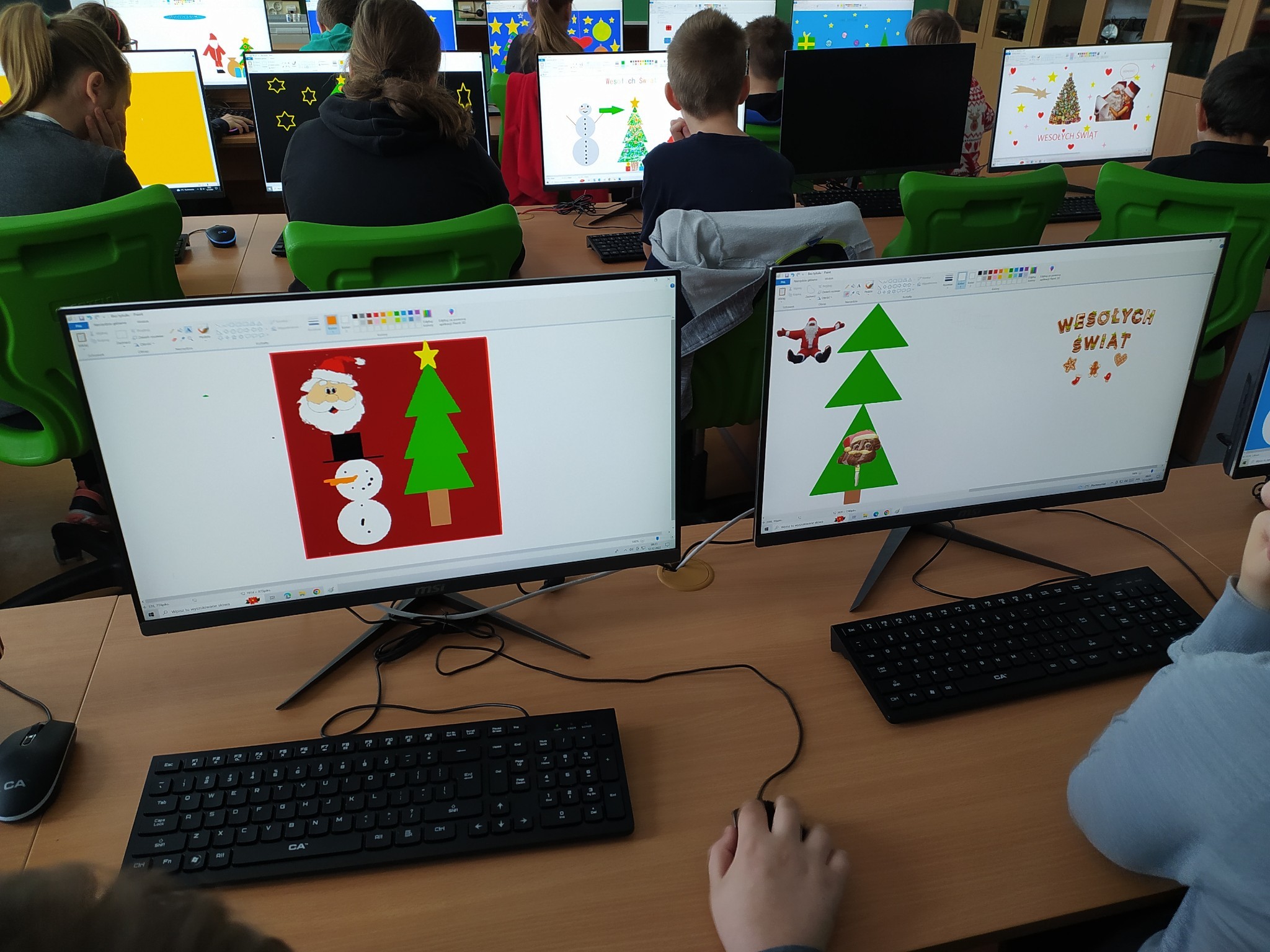 ujęcie na dzieci które robią kartki świąteczne na komputerach w programie paint