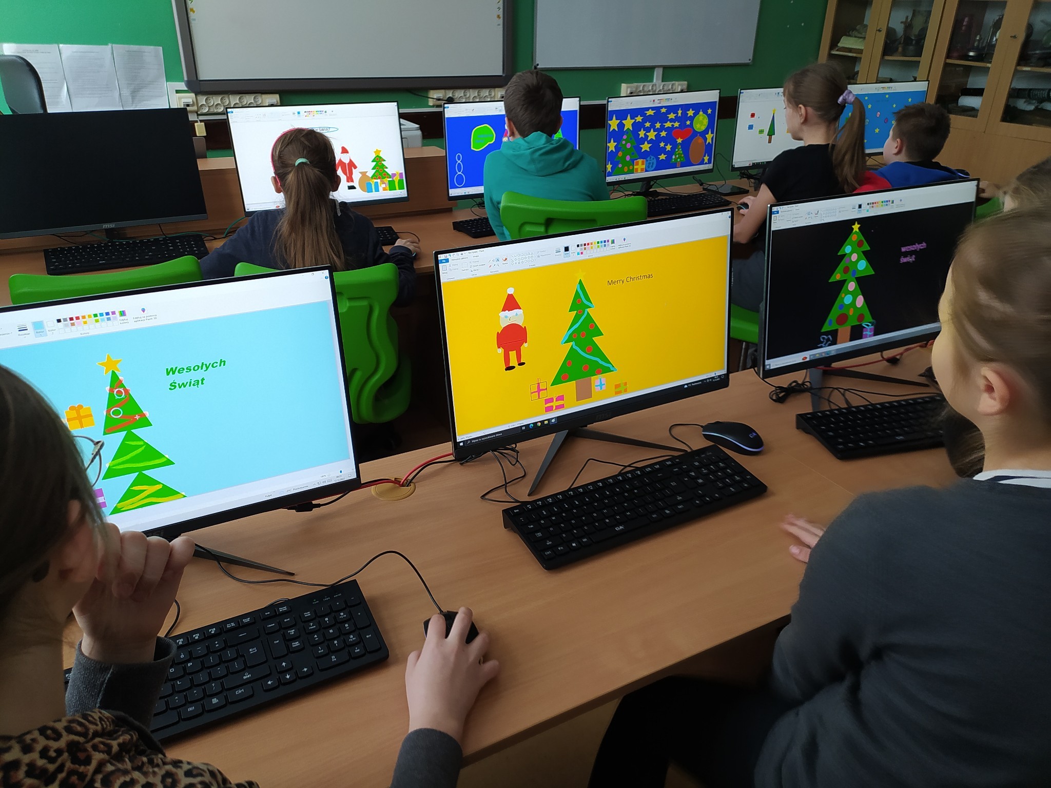 ujęcie na dzieci które robią kartki świąteczne na komputerach w programie paint