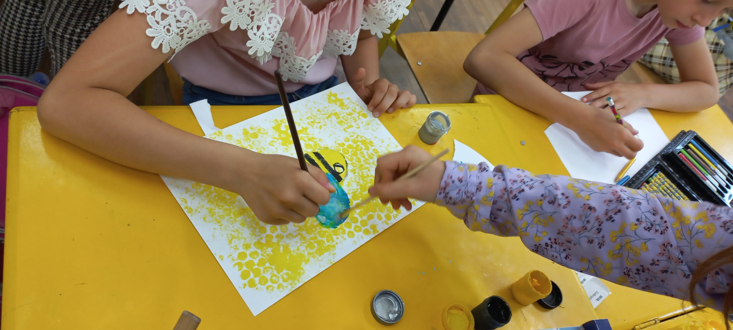 dzieci malują pszczółke i plastry miodu
