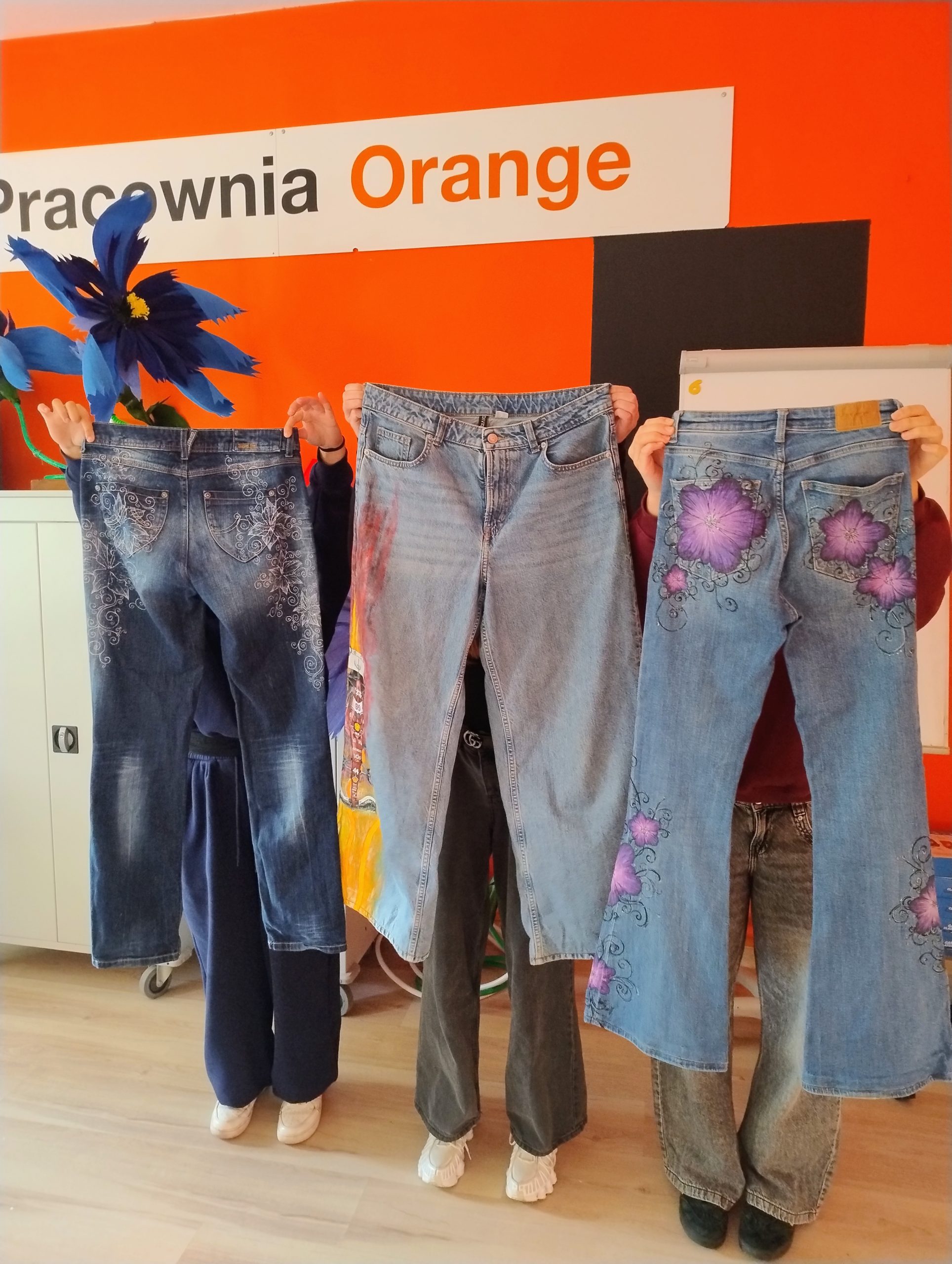 Uczestniczki warsztatów prezentują ozdobione spodnie.