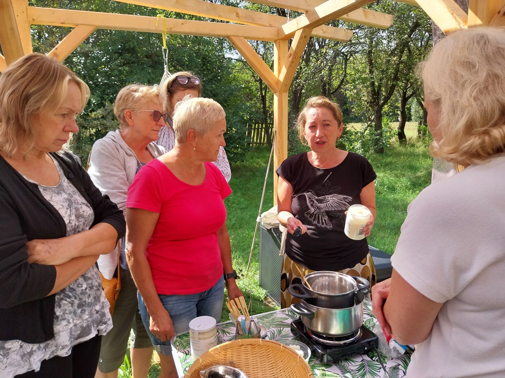 grupa uczestniczek spotkania z uwaga słucha opowieści prowadzącej