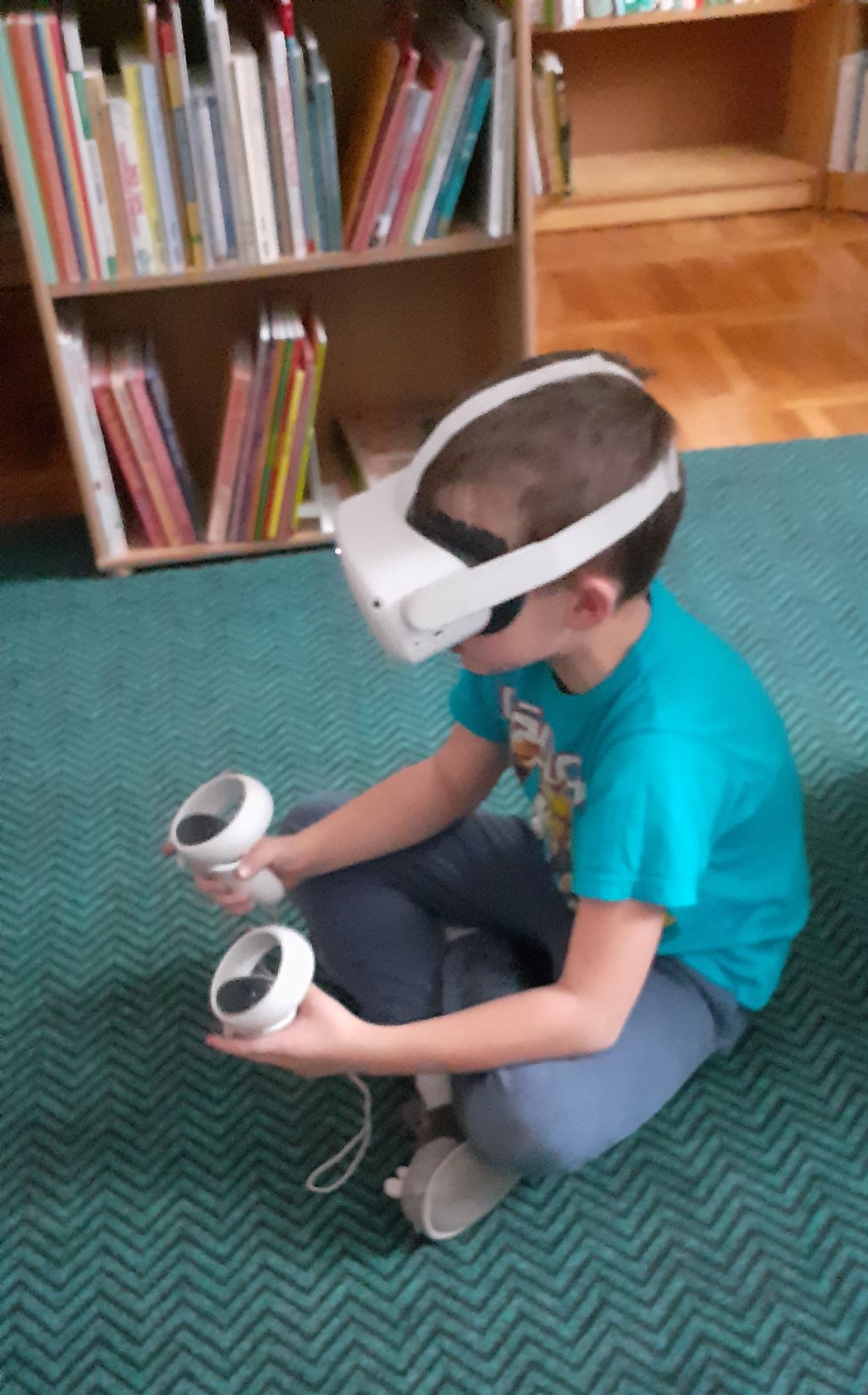 chłopiec siedzi na podłodze i ma założone okulary VR