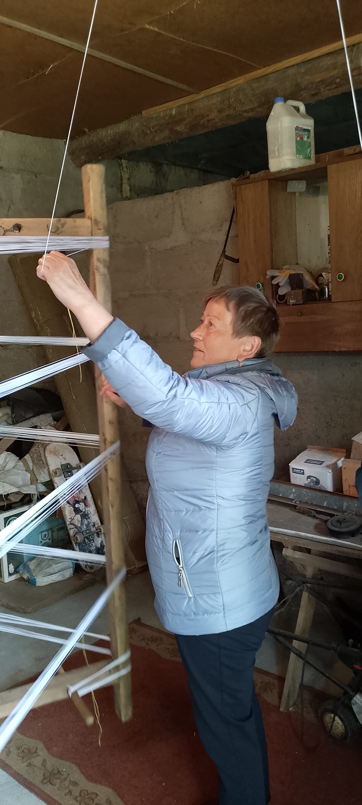 Jedna z uczestniczek snuje osnowę.