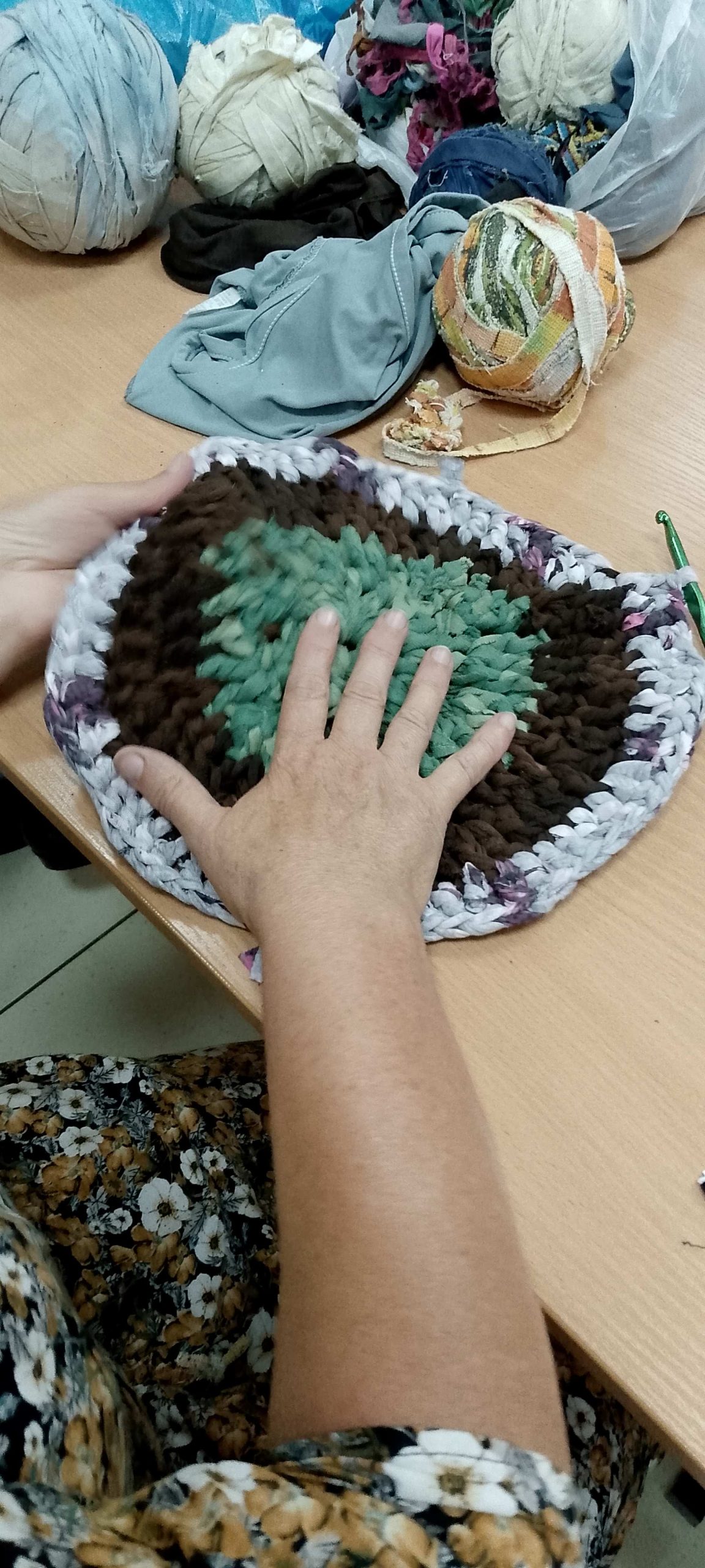 Uczestniczka warsztatów formuje chodniczek ręką.