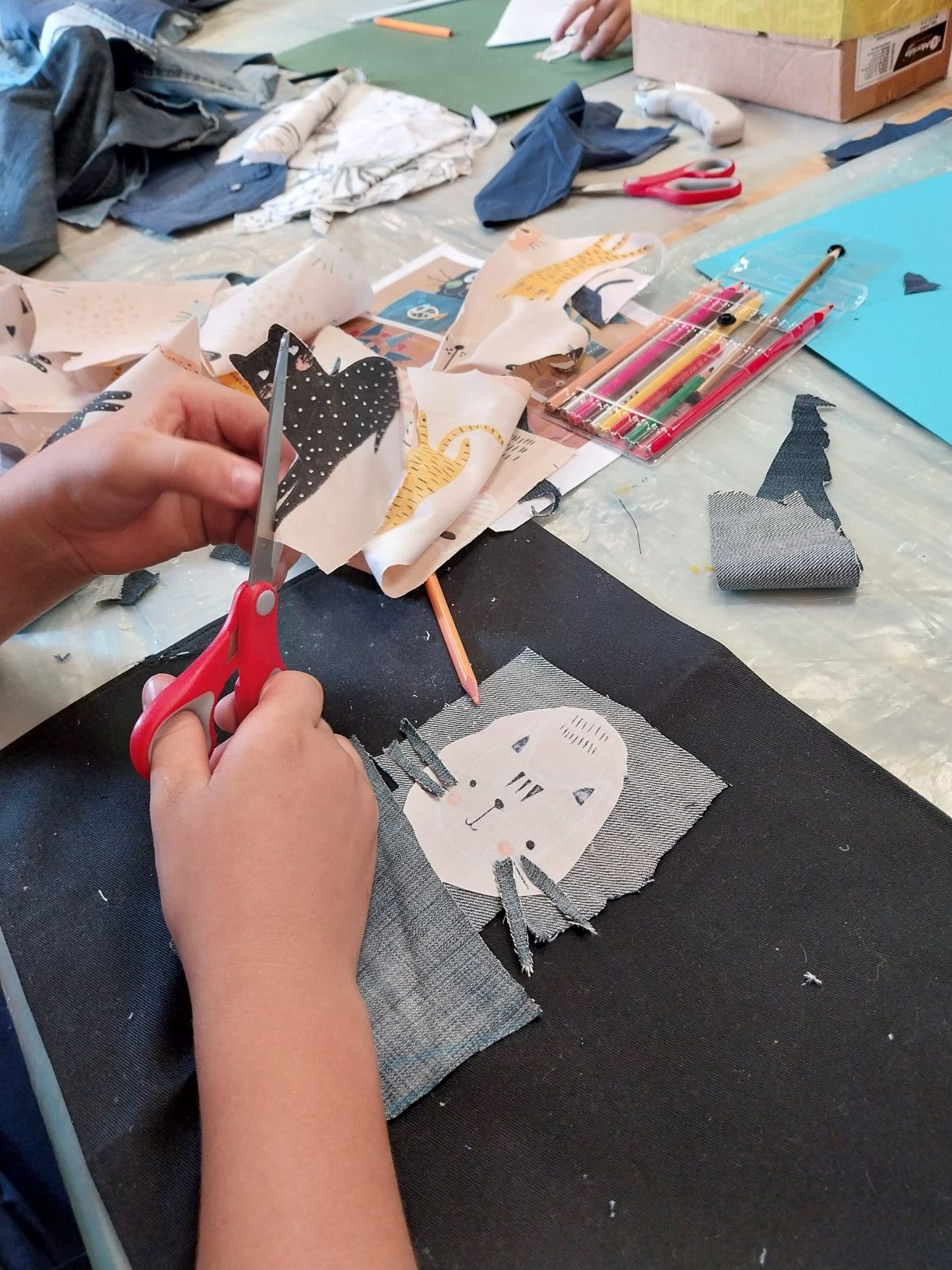 widać już pierwsze zarysy przyszłych obrazów. Uczestnik wycina i przykleja poszczególne elementy