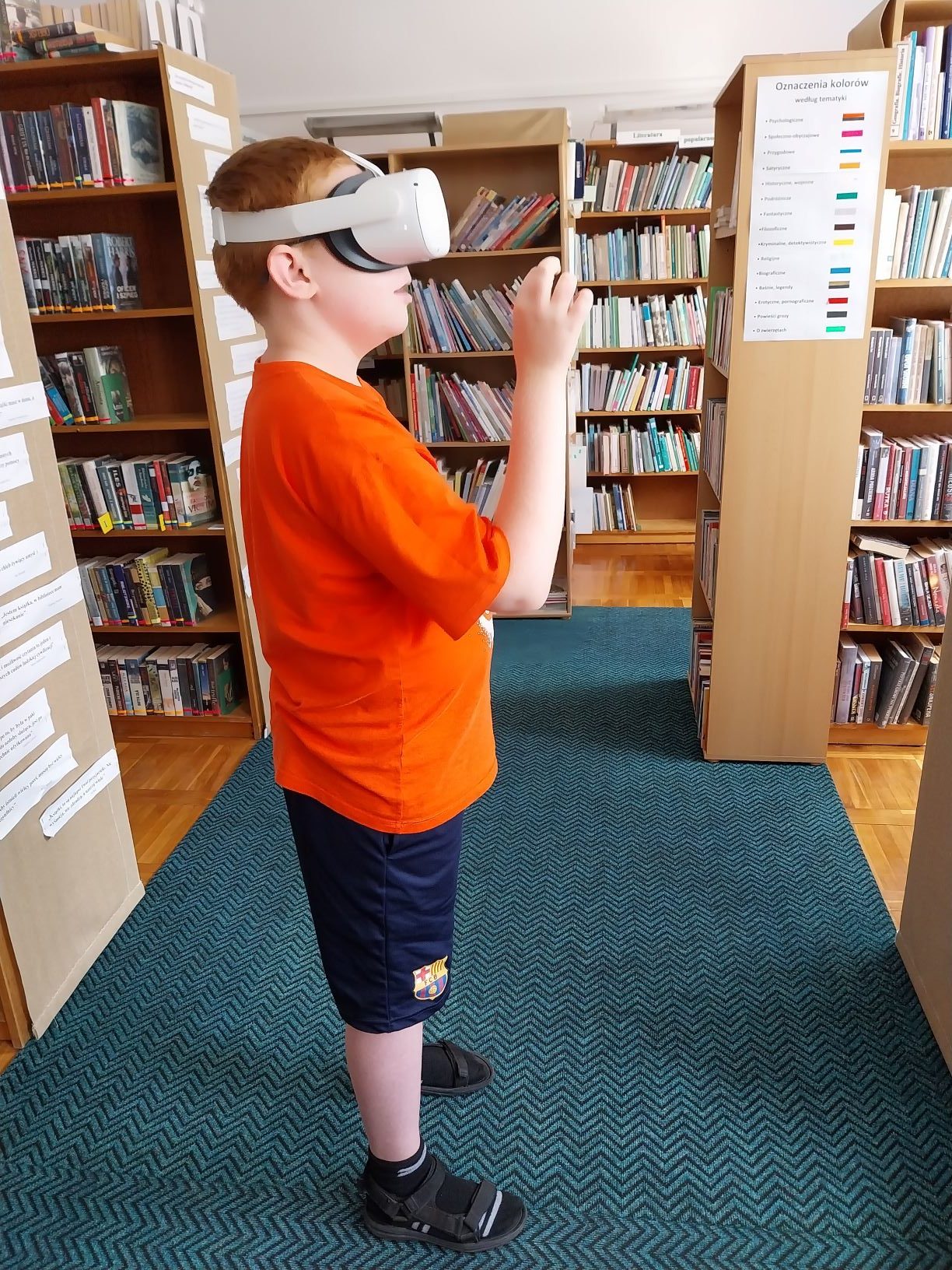 chłopiec w pomarańczowej koszulce ma założone okulary VR