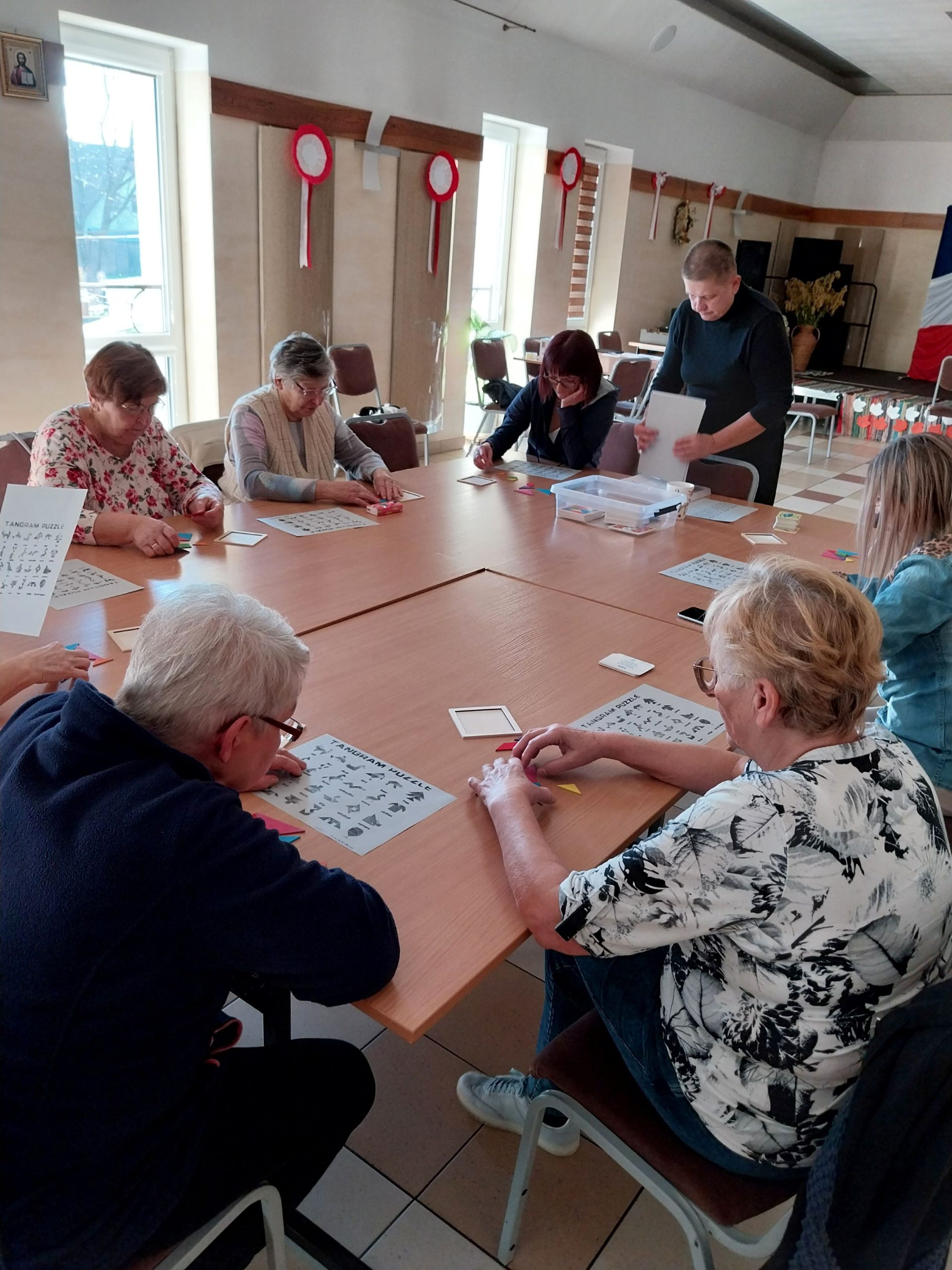 grupa kobiet siedzi przy stole i wykonuje kolejne zadanie - gra słowna państwa, miasta