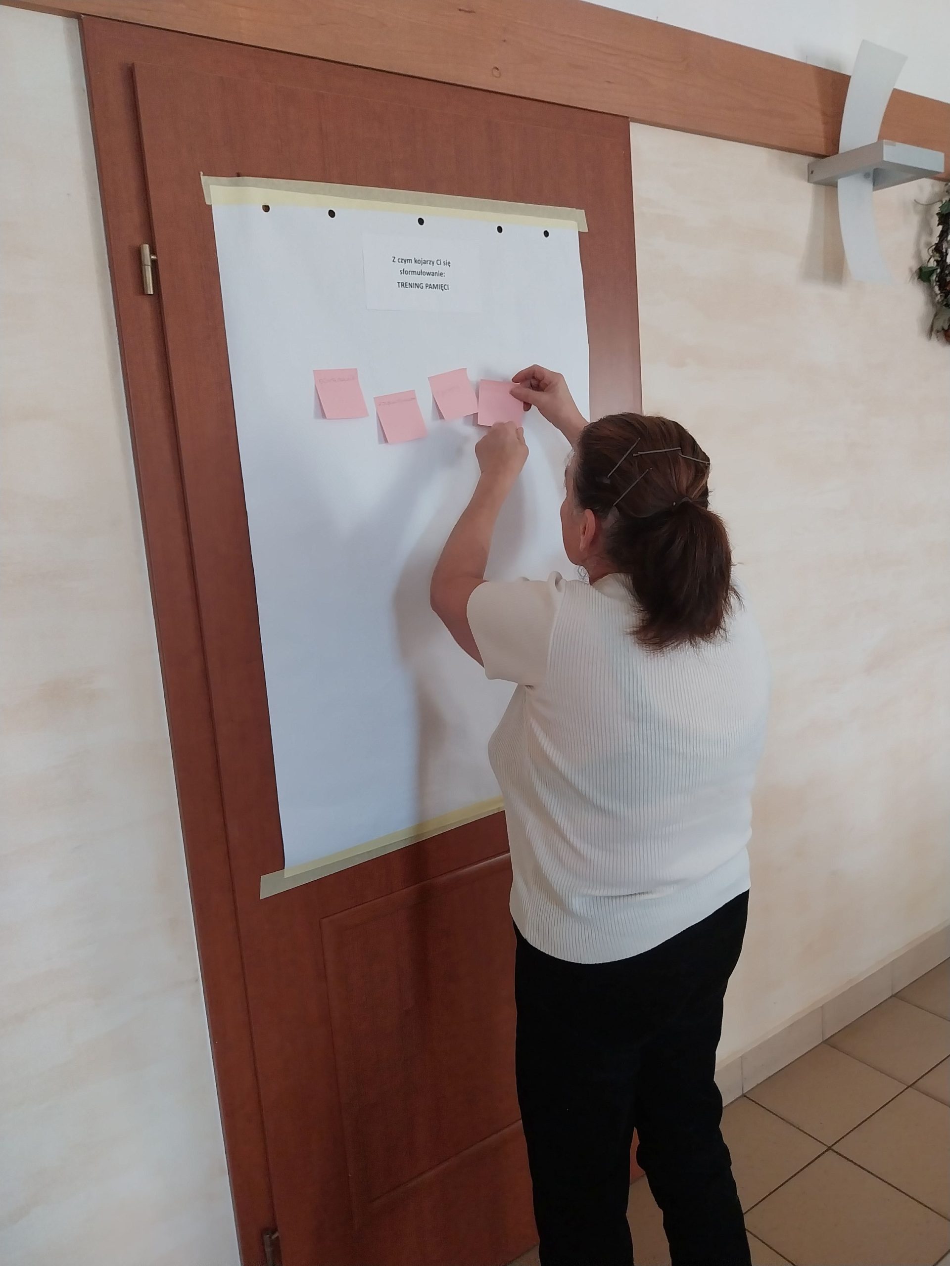 Pani N. przykleja karteczkę z skojarzeniem dotyczącym hasła