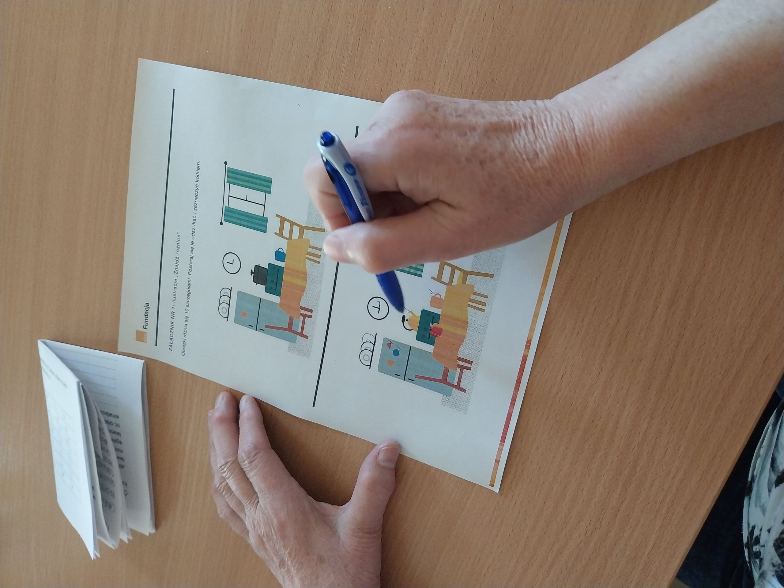 na stole leży karta zadaniowa - znajdź różnice w przedstawionych obrazkach