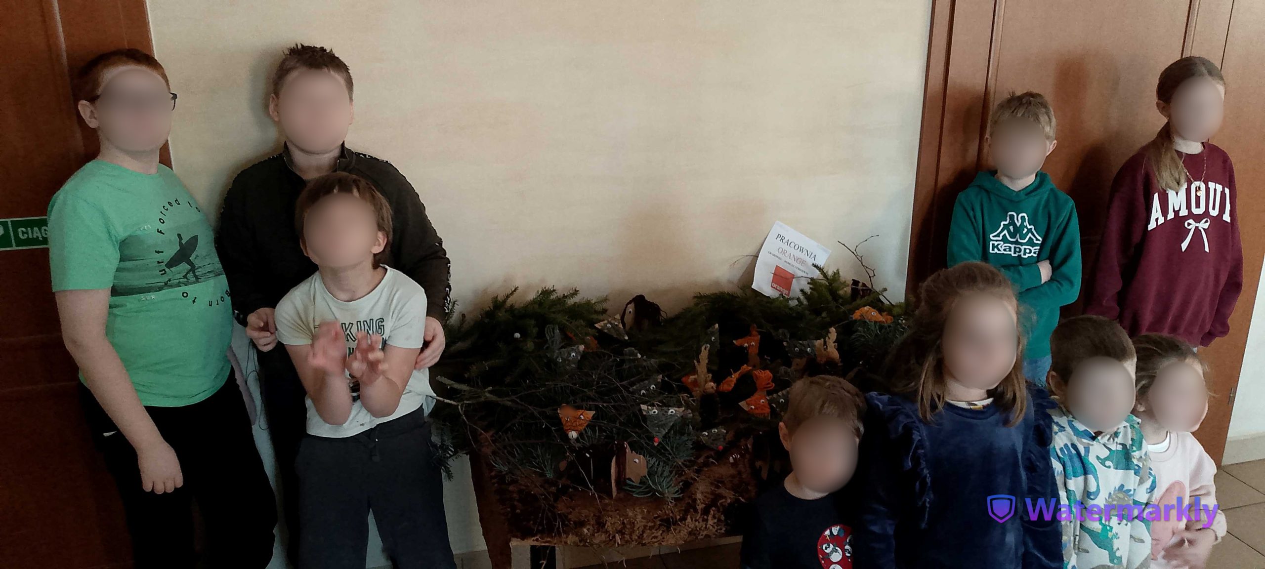 Uczestnicy warsztatów przy makiecie lasu ze zwierzętami.