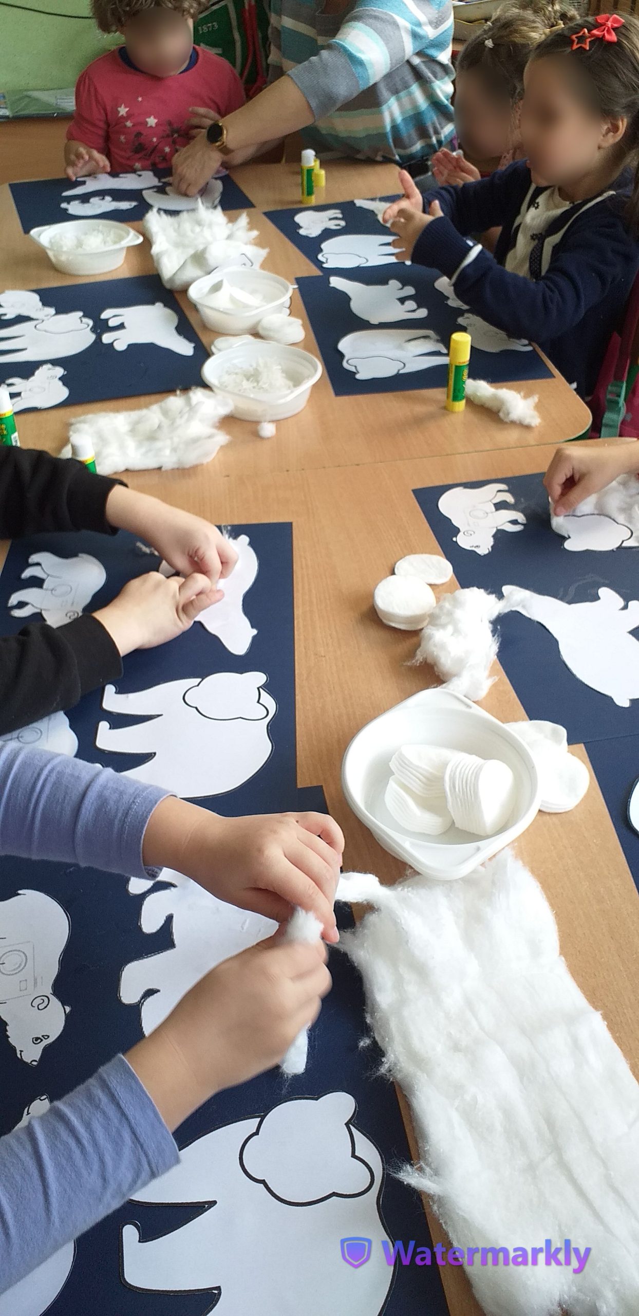 Dzieci przyklejają dekorują wata szablony niedźwiadków.