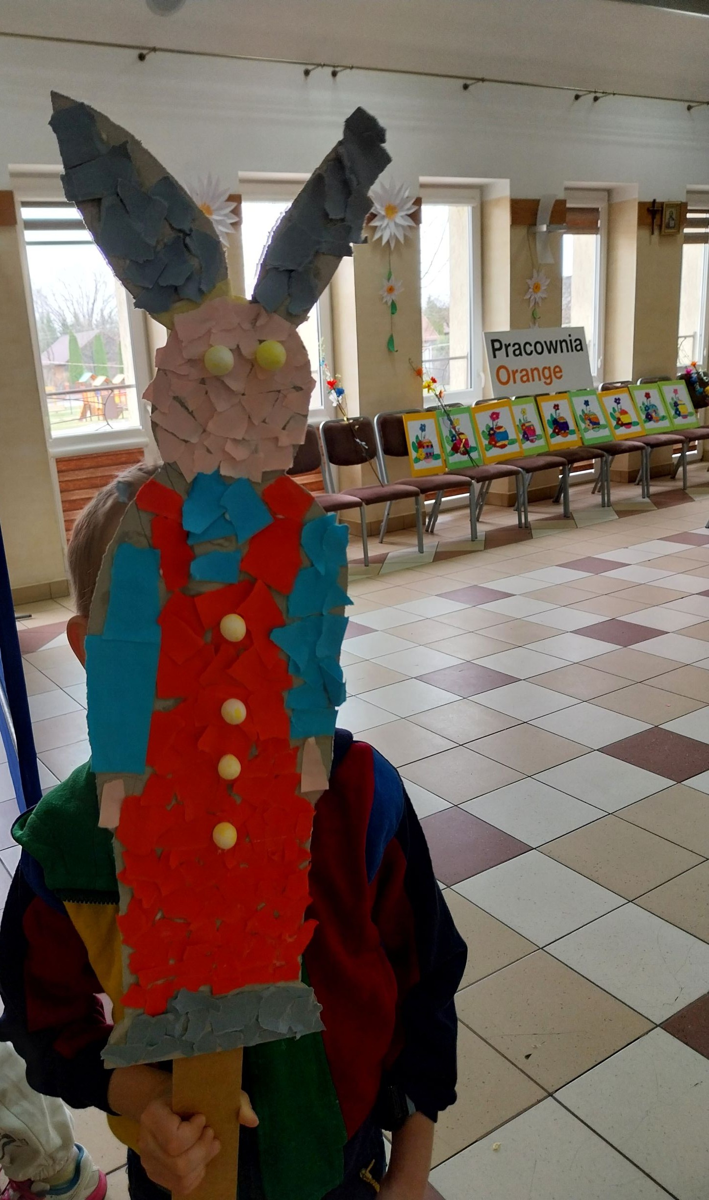 Chłopczyk prezentuje swojego papierowego zająca.