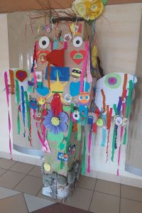 prezentacja kolorowego totemu. Pełny tasiemek i kwiatów oraz medali