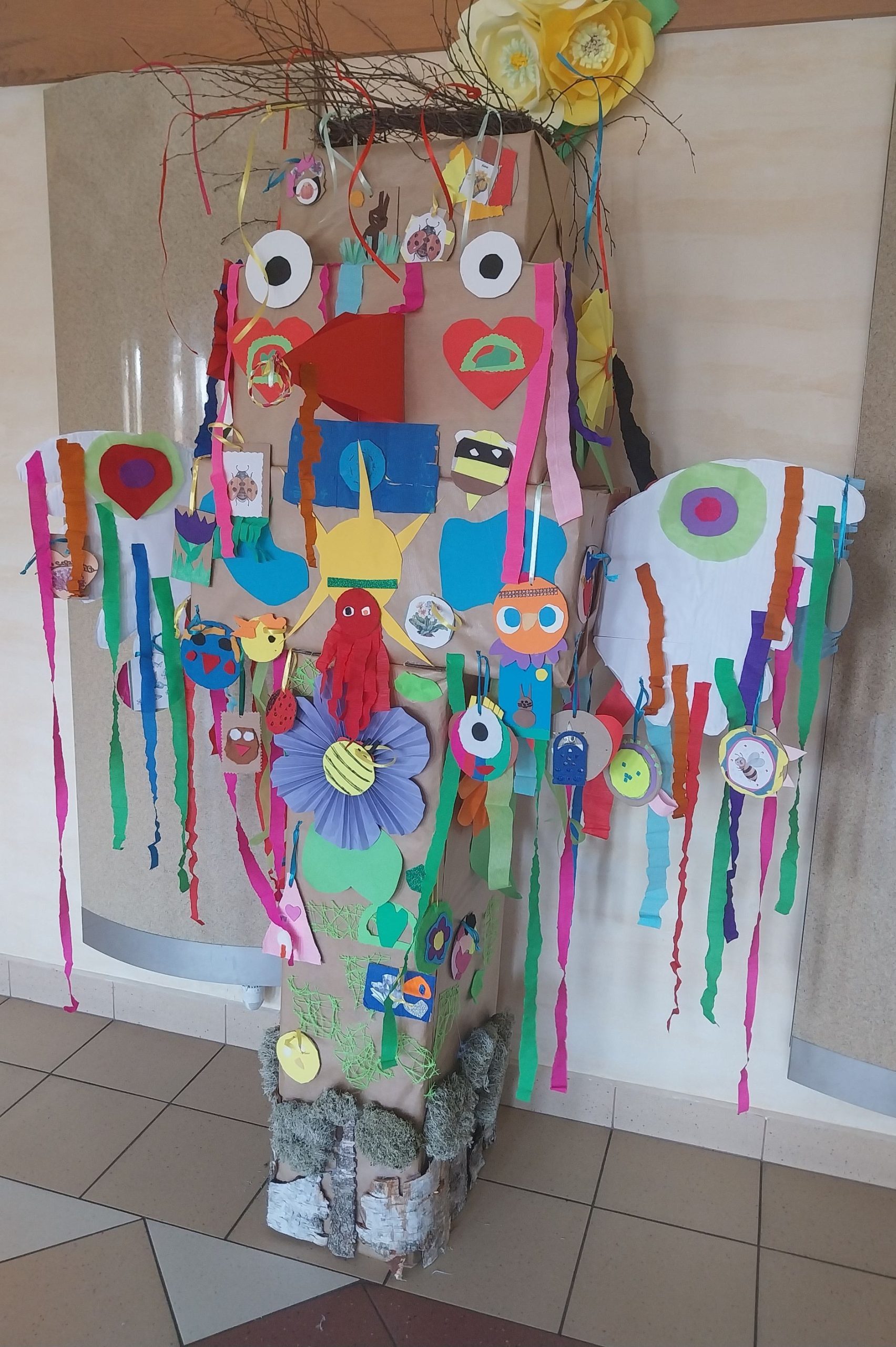 prezentacja kolorowego totemu. Pełny tasiemek i kwiatów oraz medali