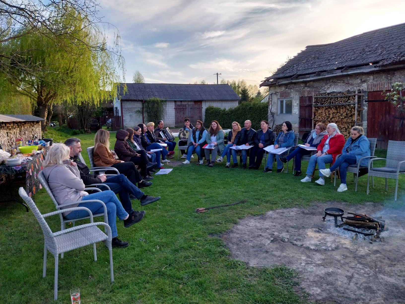 ognisko integracyjne. Grupa uczestników wizyty studyjnej oraz zespołu działającego przy domu Kultury w Niedrzwicy przy ognisku. Śpiew i wymiana doświadczeń