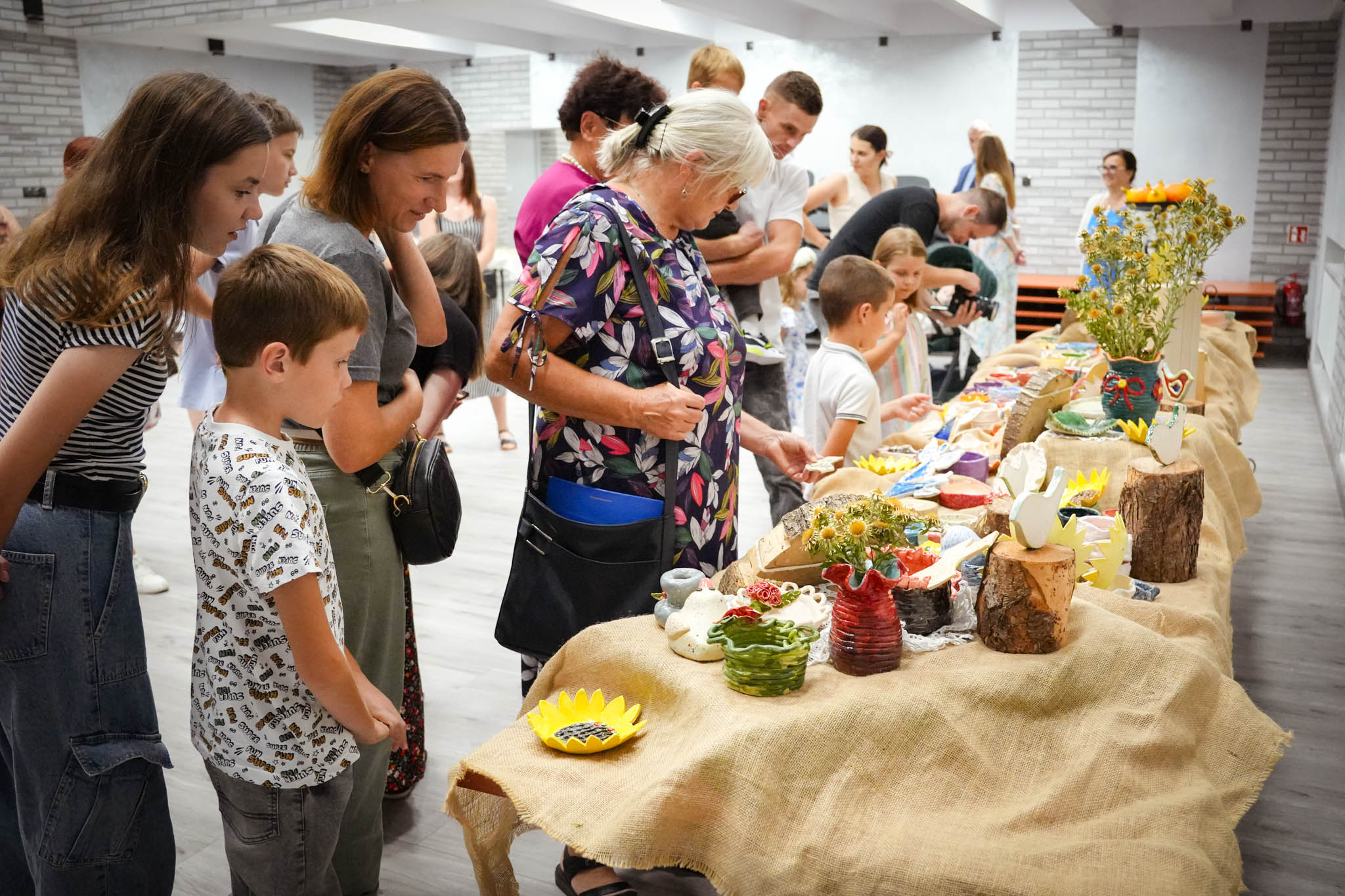 zdjęcie grupy osób oglądających ceramiczne wyroby